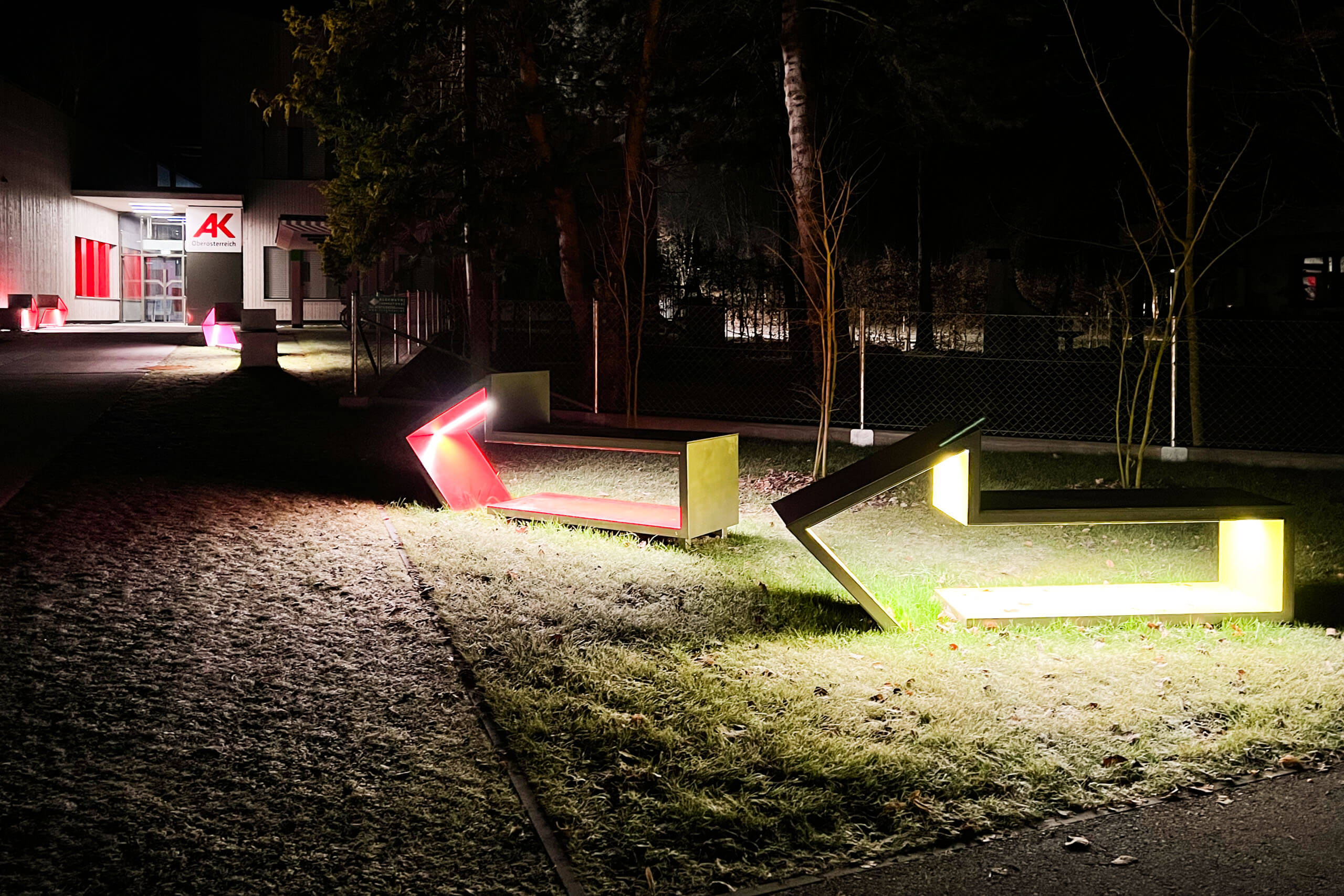 Moderne Architekturbeleuchtung von Illumina mit illuminierten Sitzgelegenheiten im Außenbereich.