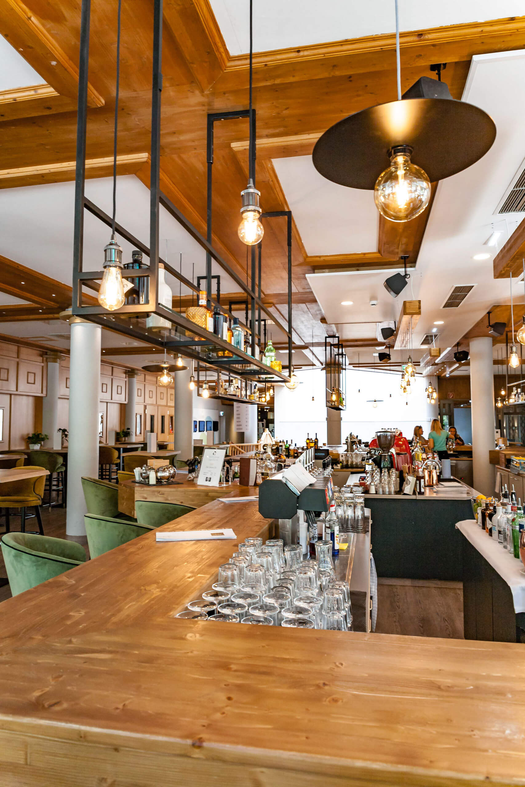 Bar-Bereich mit Holztresen, Gläsern und stimmungsvoller Beleuchtung