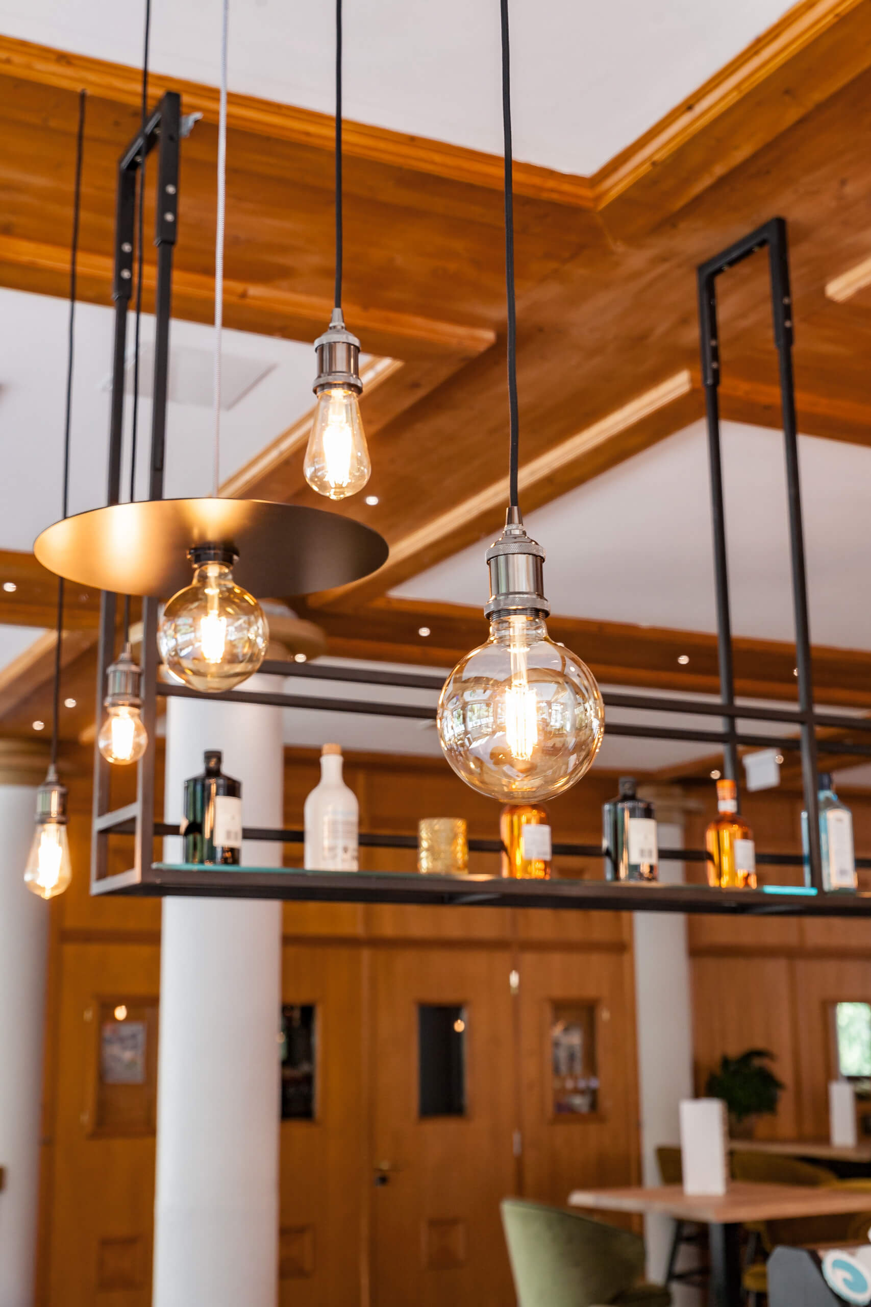 Illuminas Lichtplanung: Gemütliche Bar-Atmosphäre mit Edison-Glühbirnen und Flaschenregal.