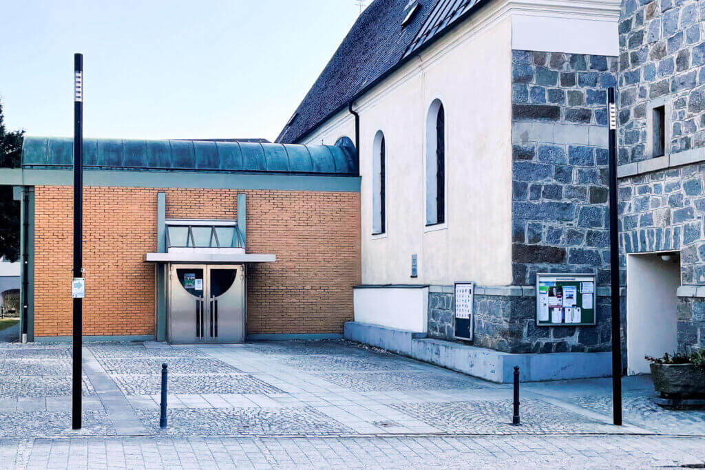 Moderne Kirche mit Klinker-Anbau und stilvoller Außenbeleuchtung