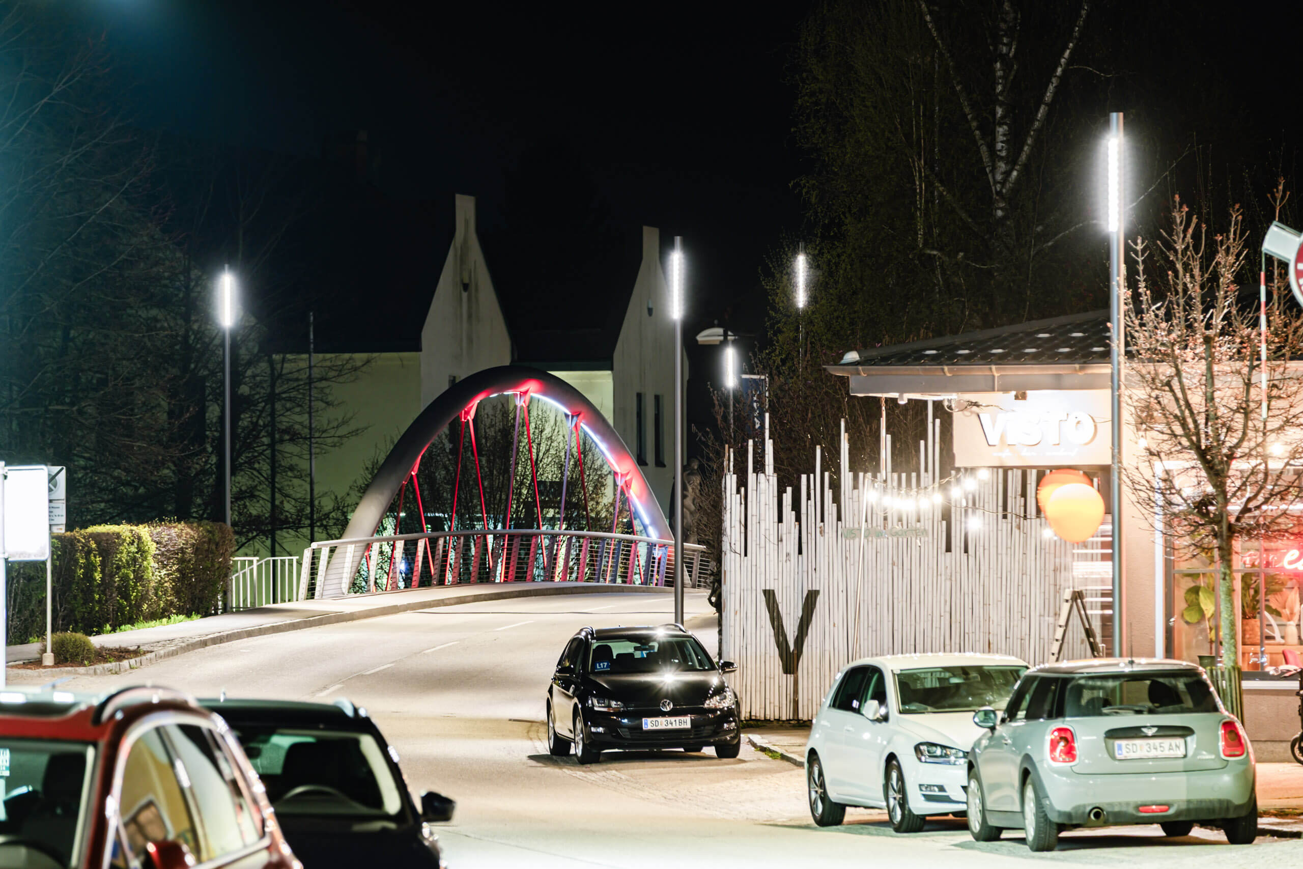 Nachtaufnahme einer beleuchteten Brücke mit Autos und Gebäuden, Architekturbeleuchtung