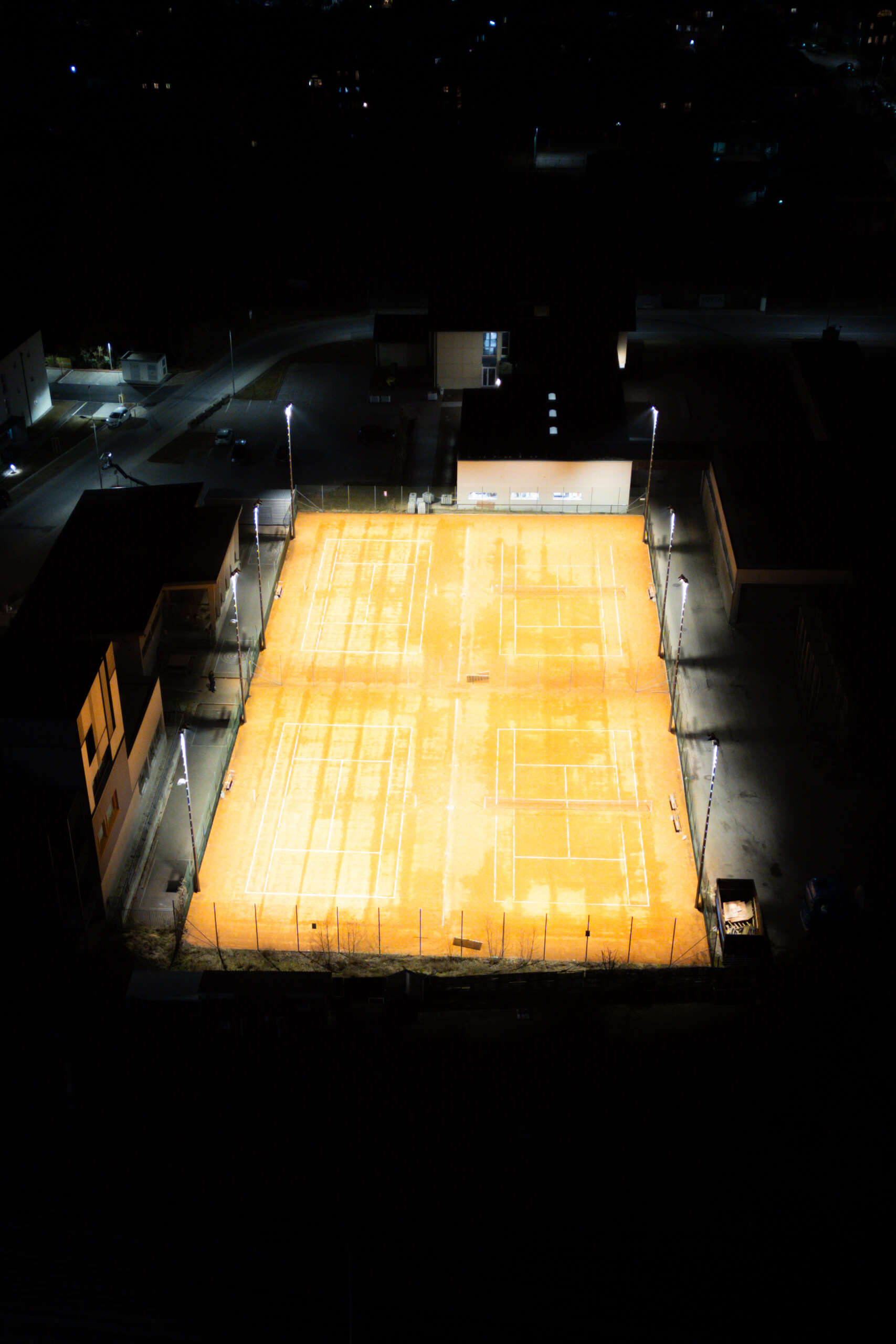 Tennisplatz bei Nacht, beleuchtet von professionellen Sportplatzleuchten