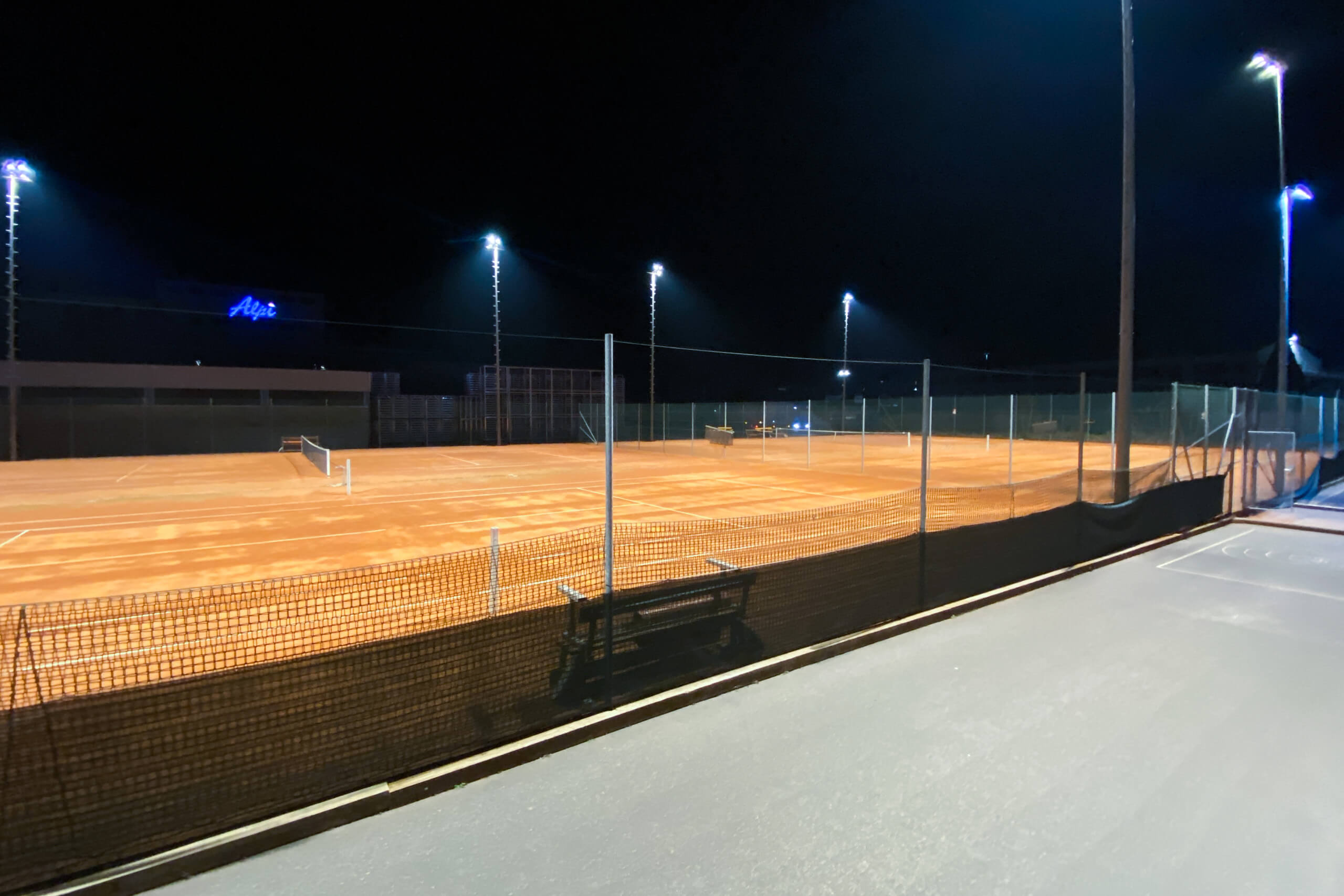 Beleuchtete Tennisplätze bei Nacht mit Illumina Sportplatzbeleuchtung