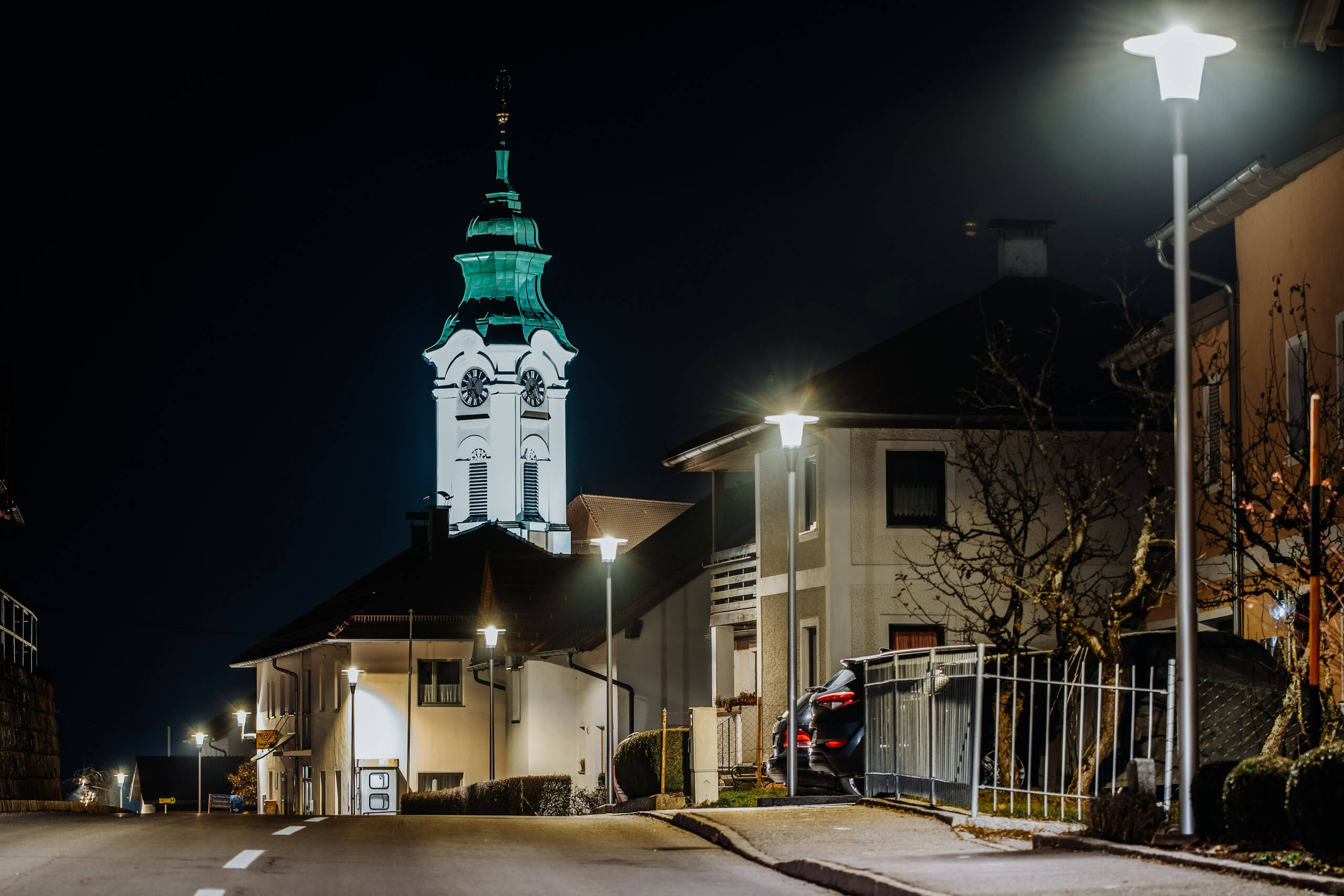 Architekturbeleuchtung: Kirche und Gebäude werden nachts angestrahlt.