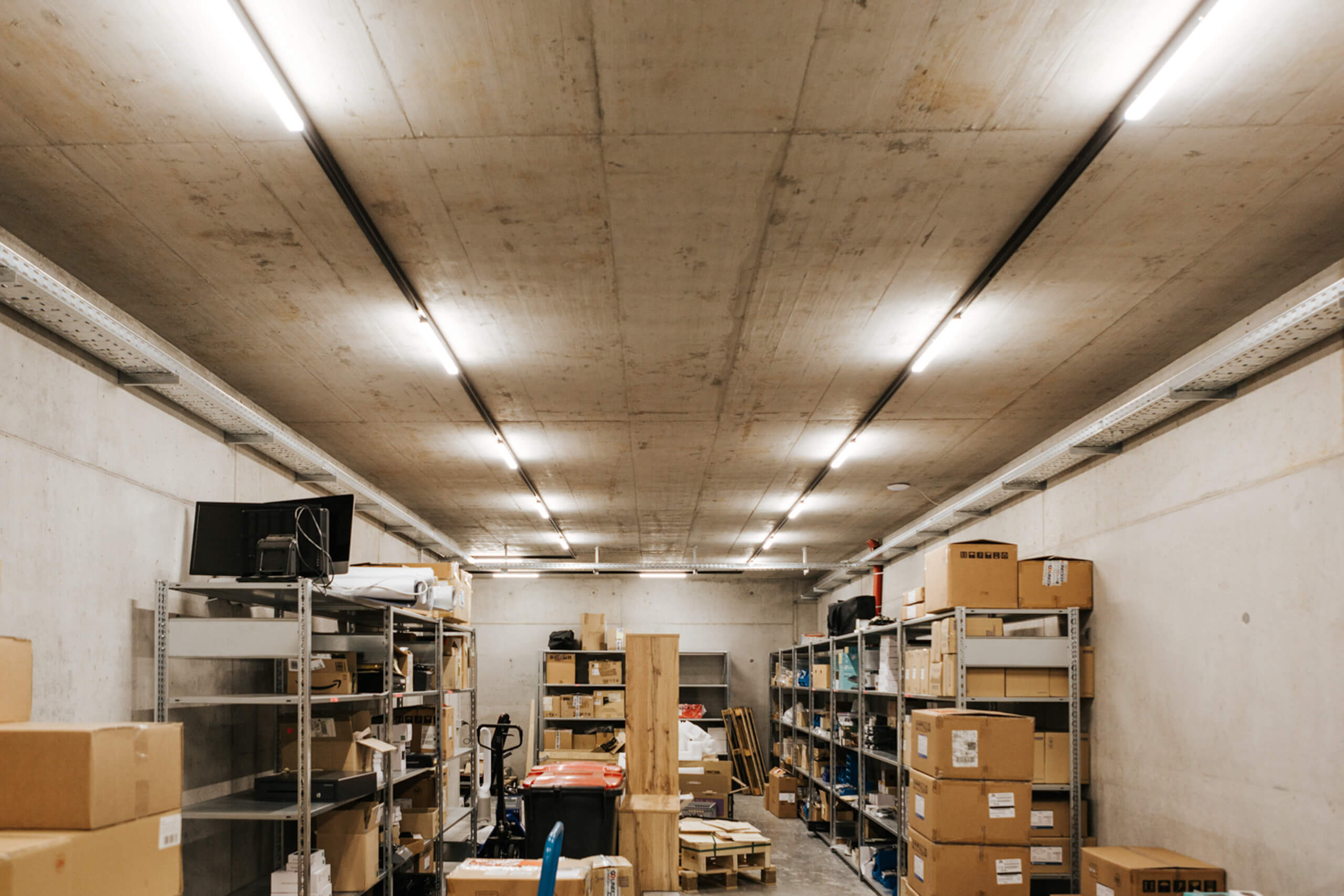 Gewerbliche Lagerhalle mit Betonlicht und Regalen – Lichtberechnung von Illumina.