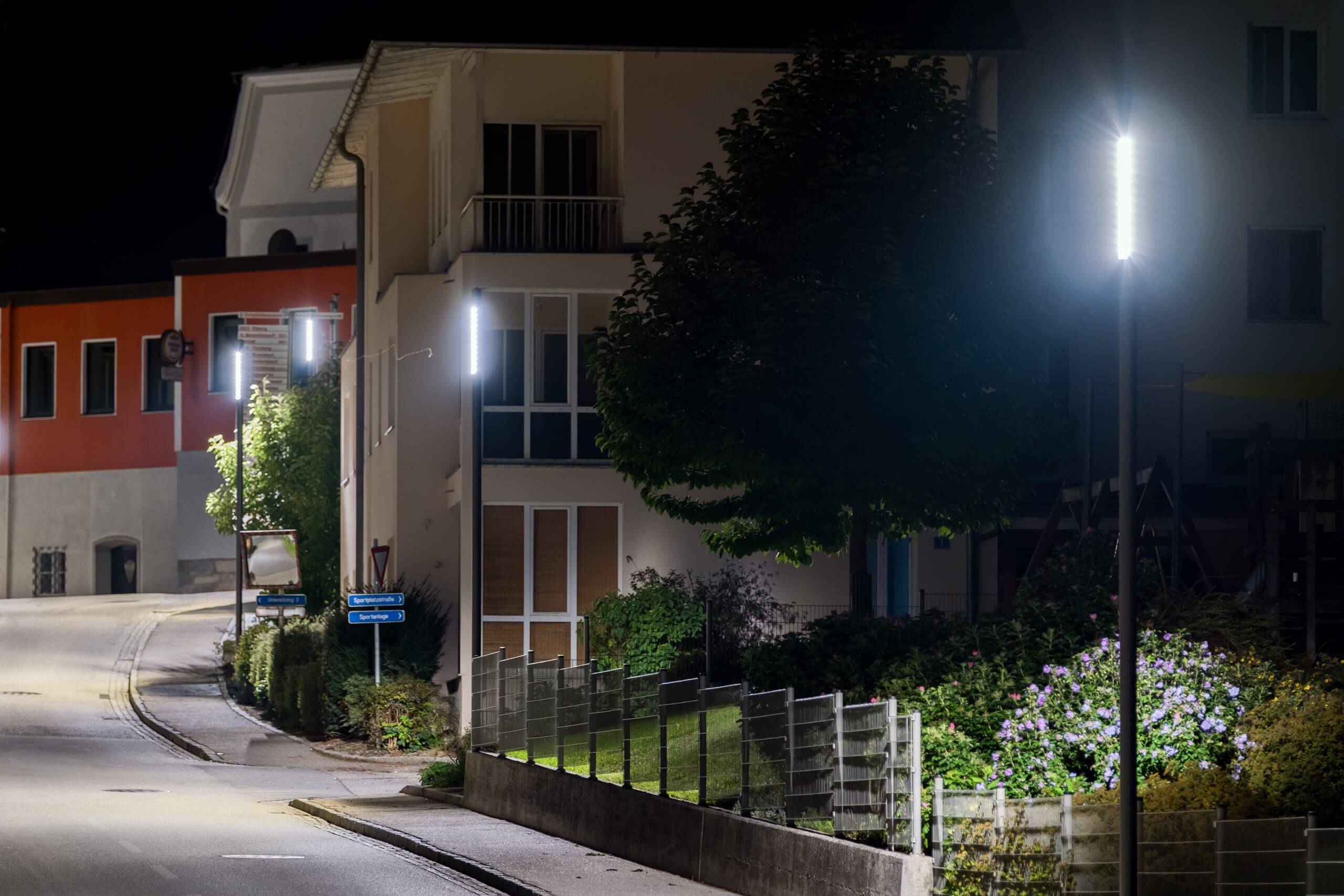 Straßenbeleuchtung in einer Siedlung bei Nacht, beleuchtet von modernen LED-Leuchten.