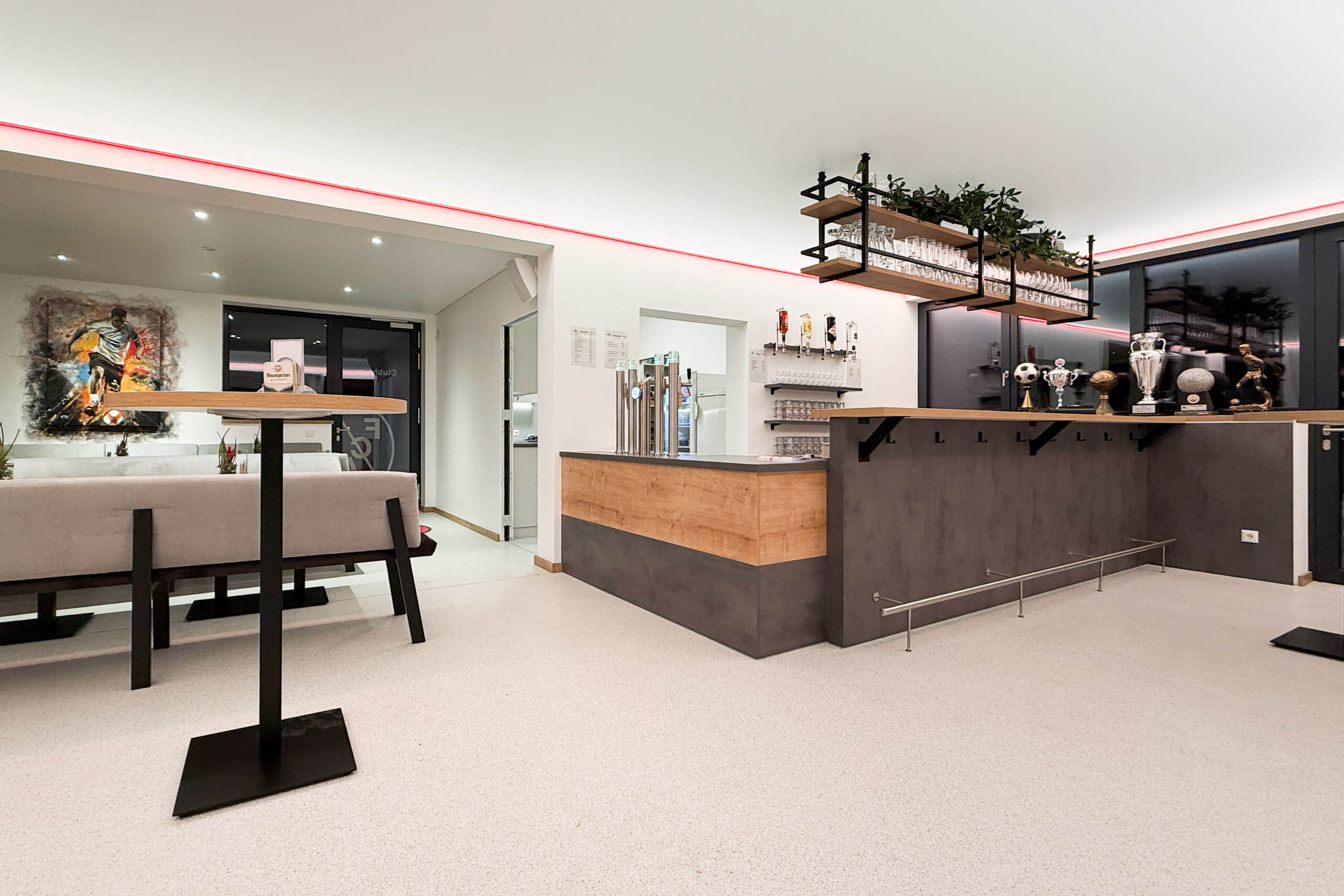 Moderne Bar mit indirekter Beleuchtung und Fußball-Trophäen – Lichtplanung von Illumina