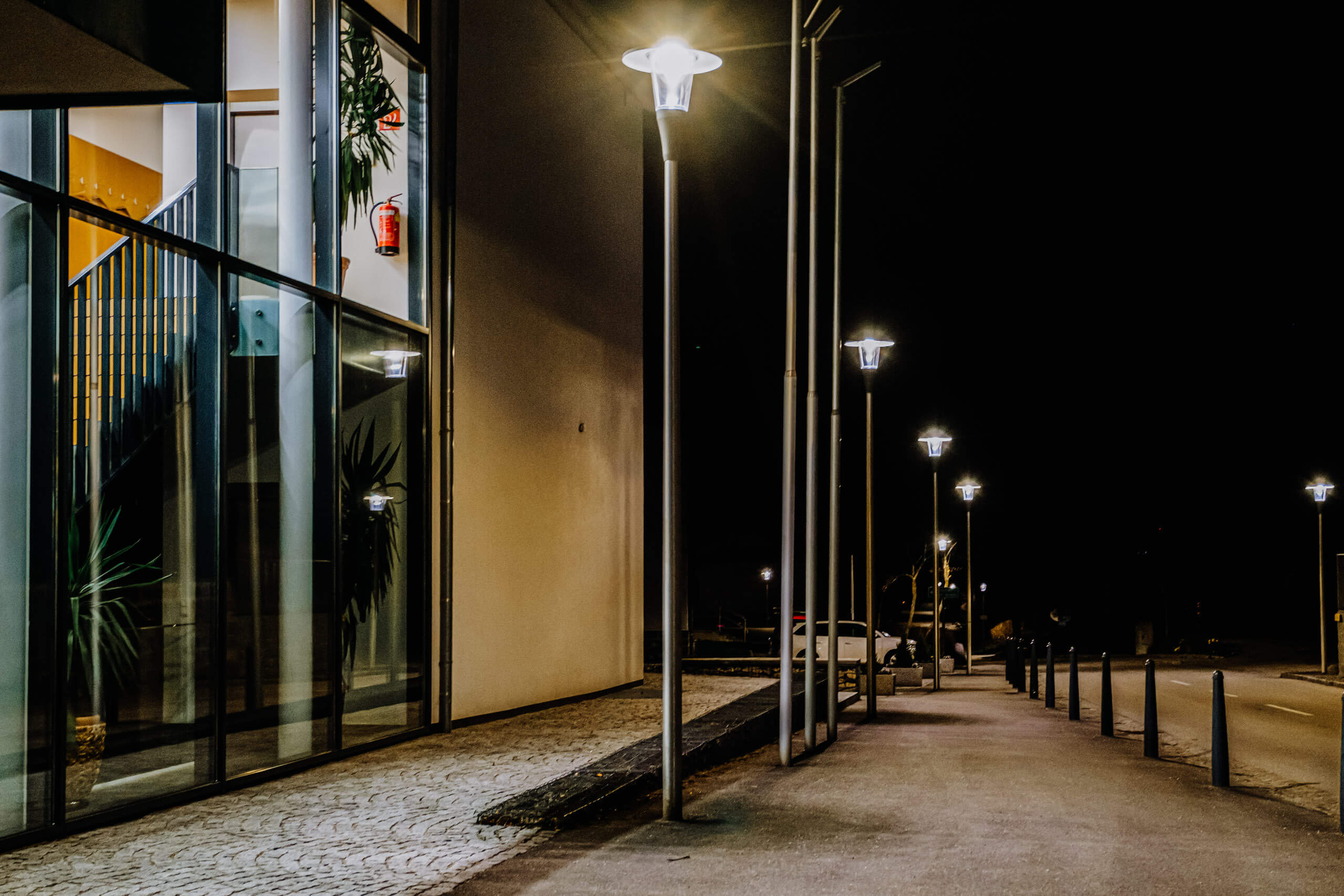 Gebäudeanstrahlung bei Nacht mit modernen Leuchten und Glasfassade