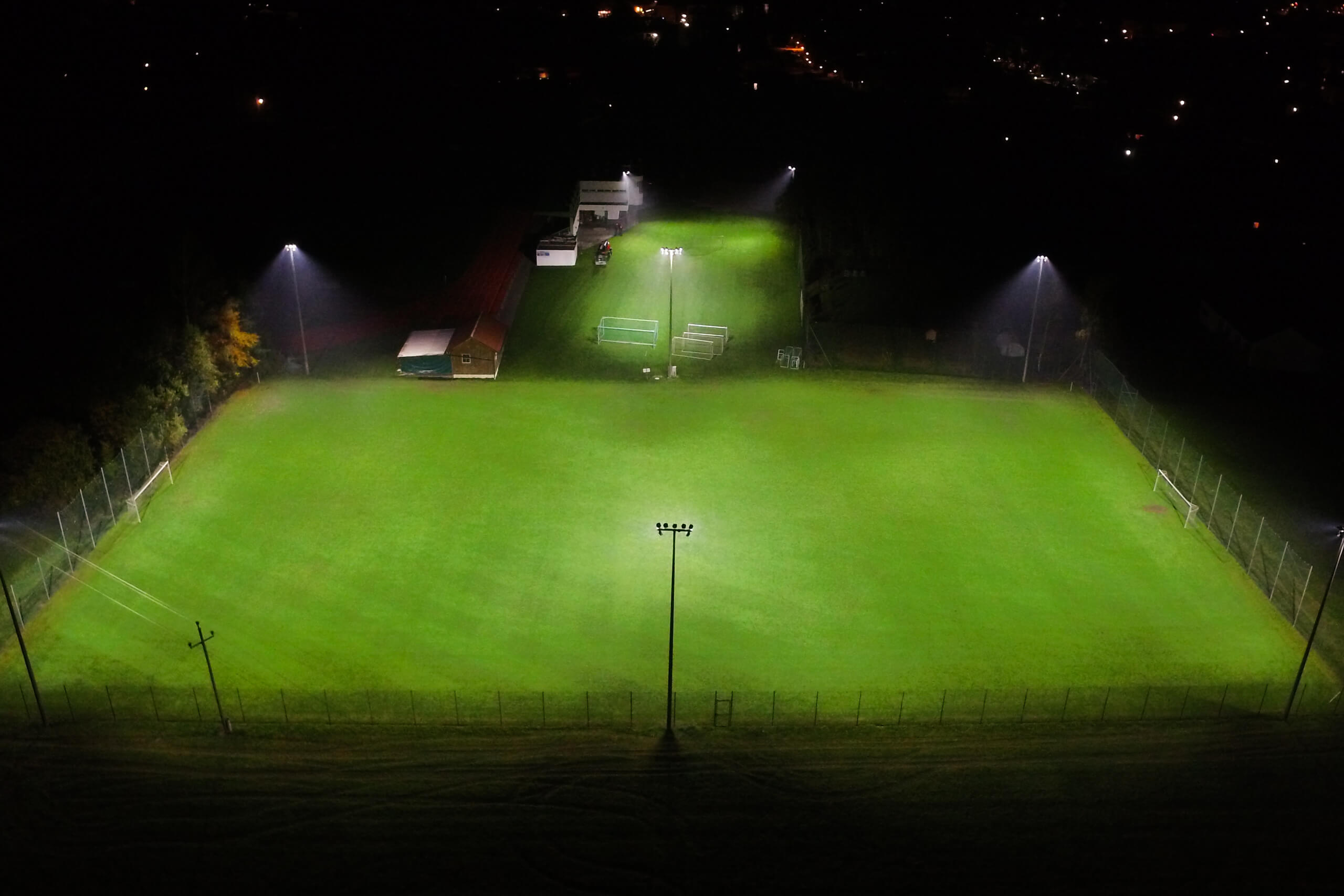 Illumina: Nachtansicht eines beleuchteten Sportplatzes mit Flutlichtanlagen.