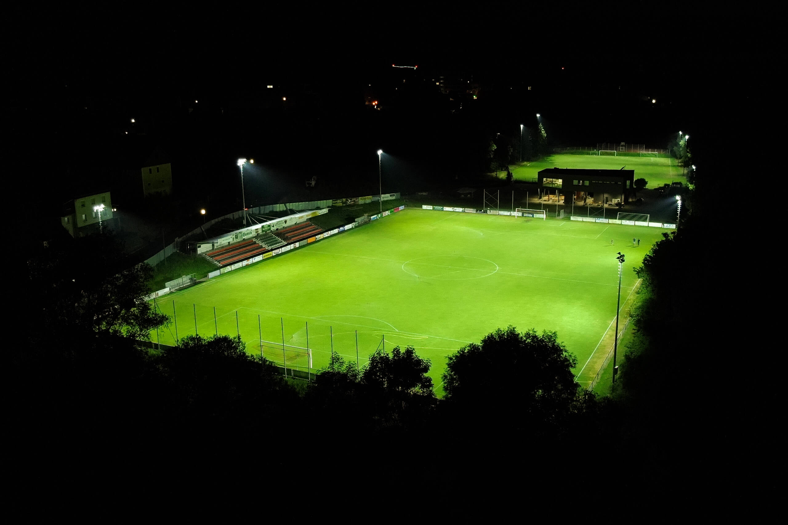Illuminas Lichtplanung: Fußballplatz bei Nacht, beleuchtet durch moderne Flutlichtstrahler.