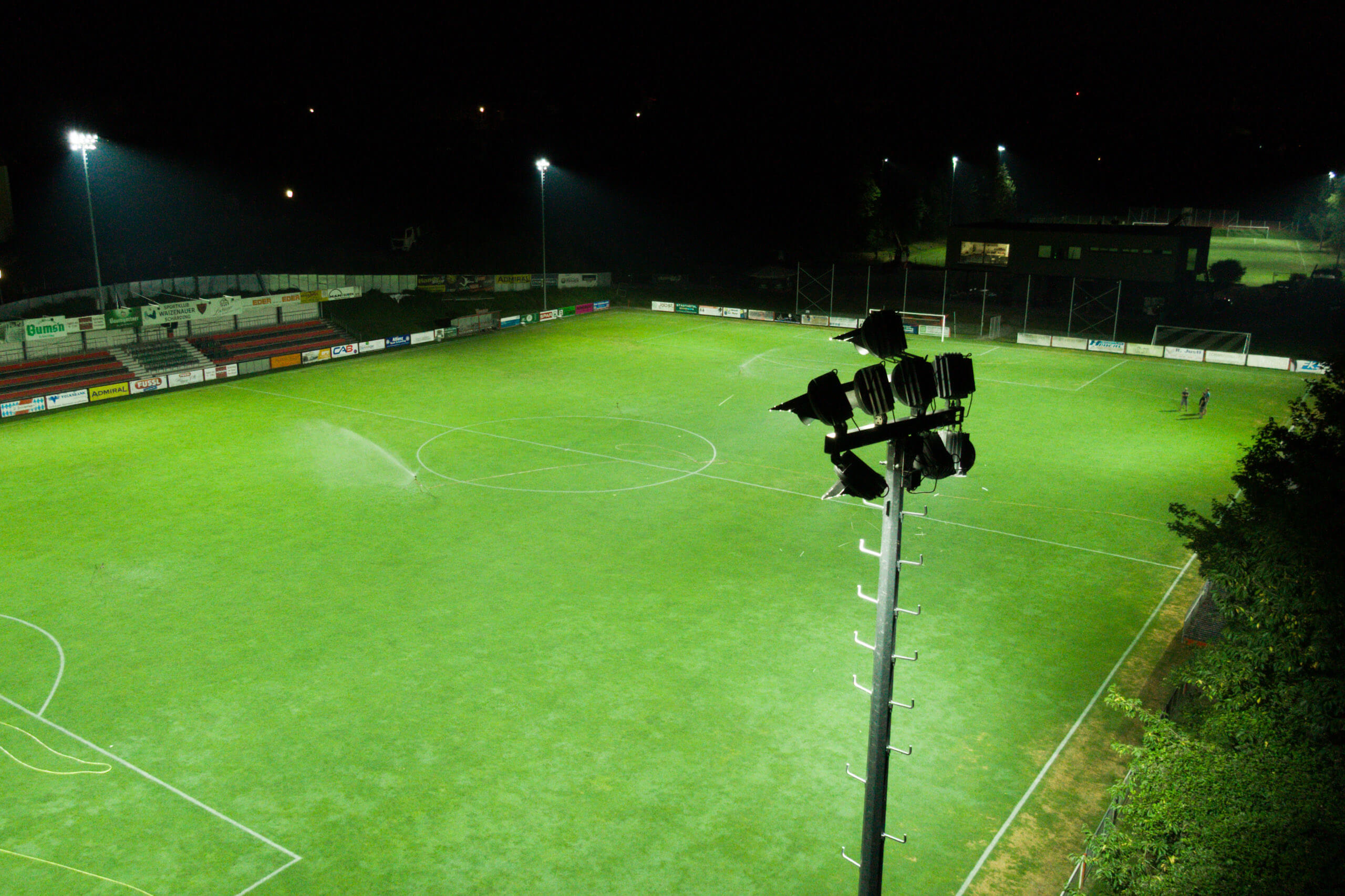 Fußballplatz mit Flutlichtanlage bei Nacht – Sportplatzbeleuchtung von Illumina