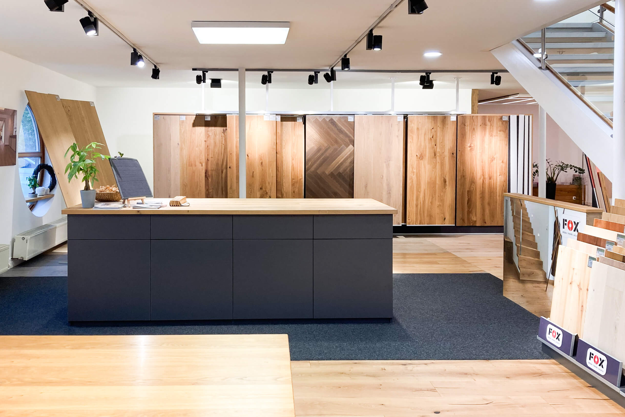 Bodenmuster-Ausstellung mit verschiedenen Holzoptiken und zentraler Theke