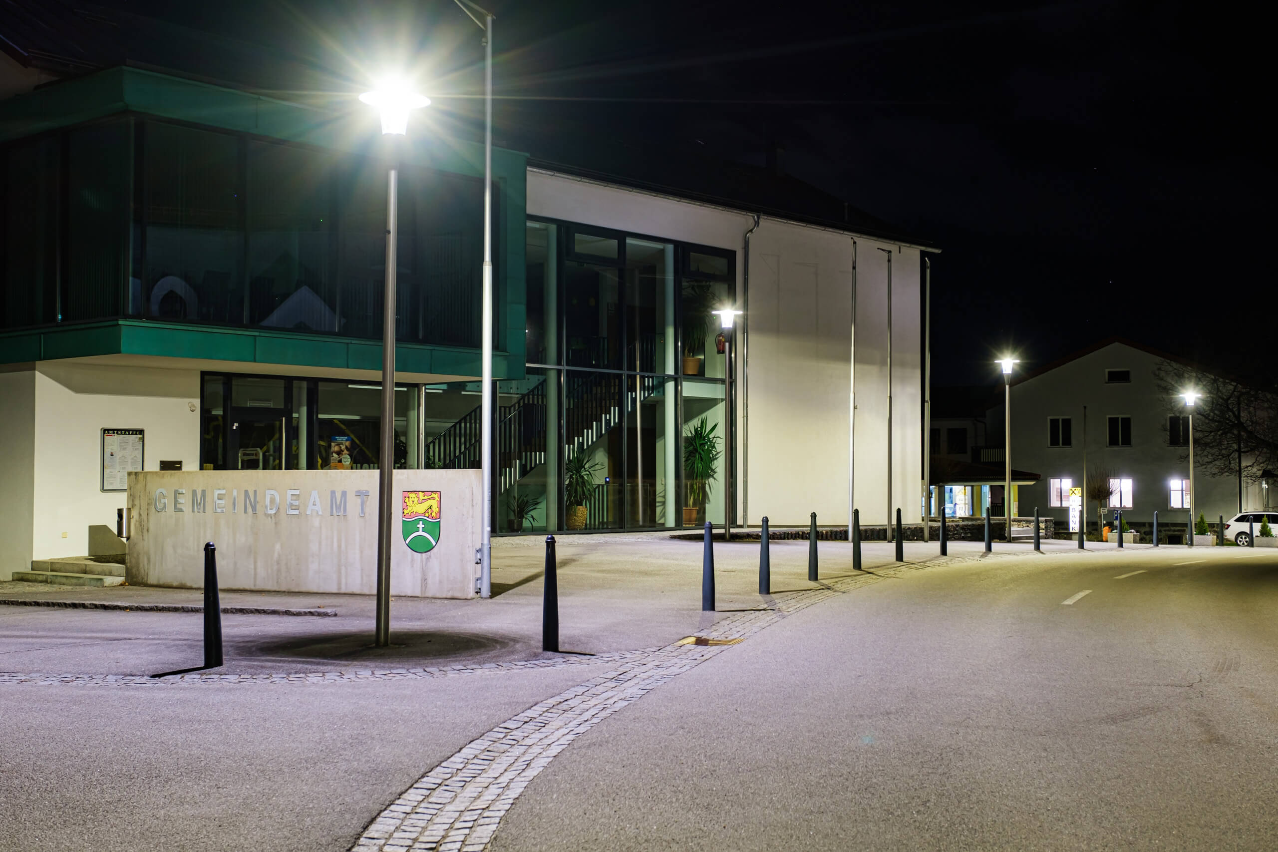 Gemeindeamt bei Nacht mit Straßenbeleuchtung und Architekturbeleuchtung