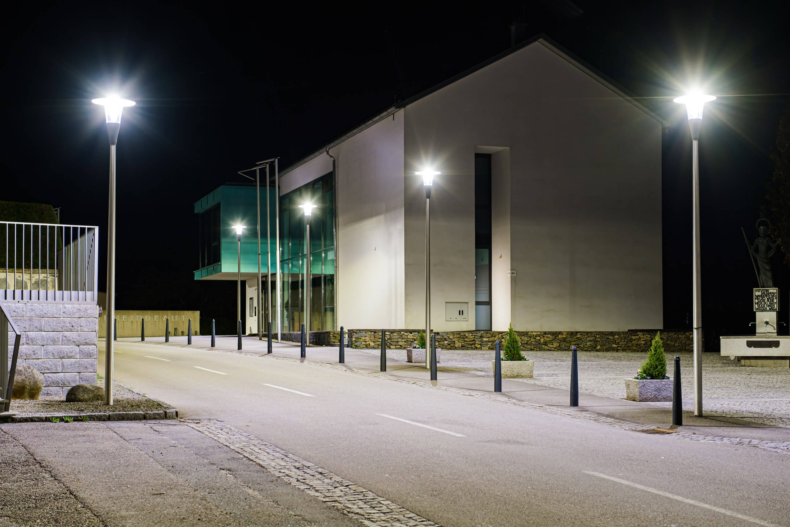 Moderne Architektur mit stimmungsvoller Außenbeleuchtung und Straßenlampen.