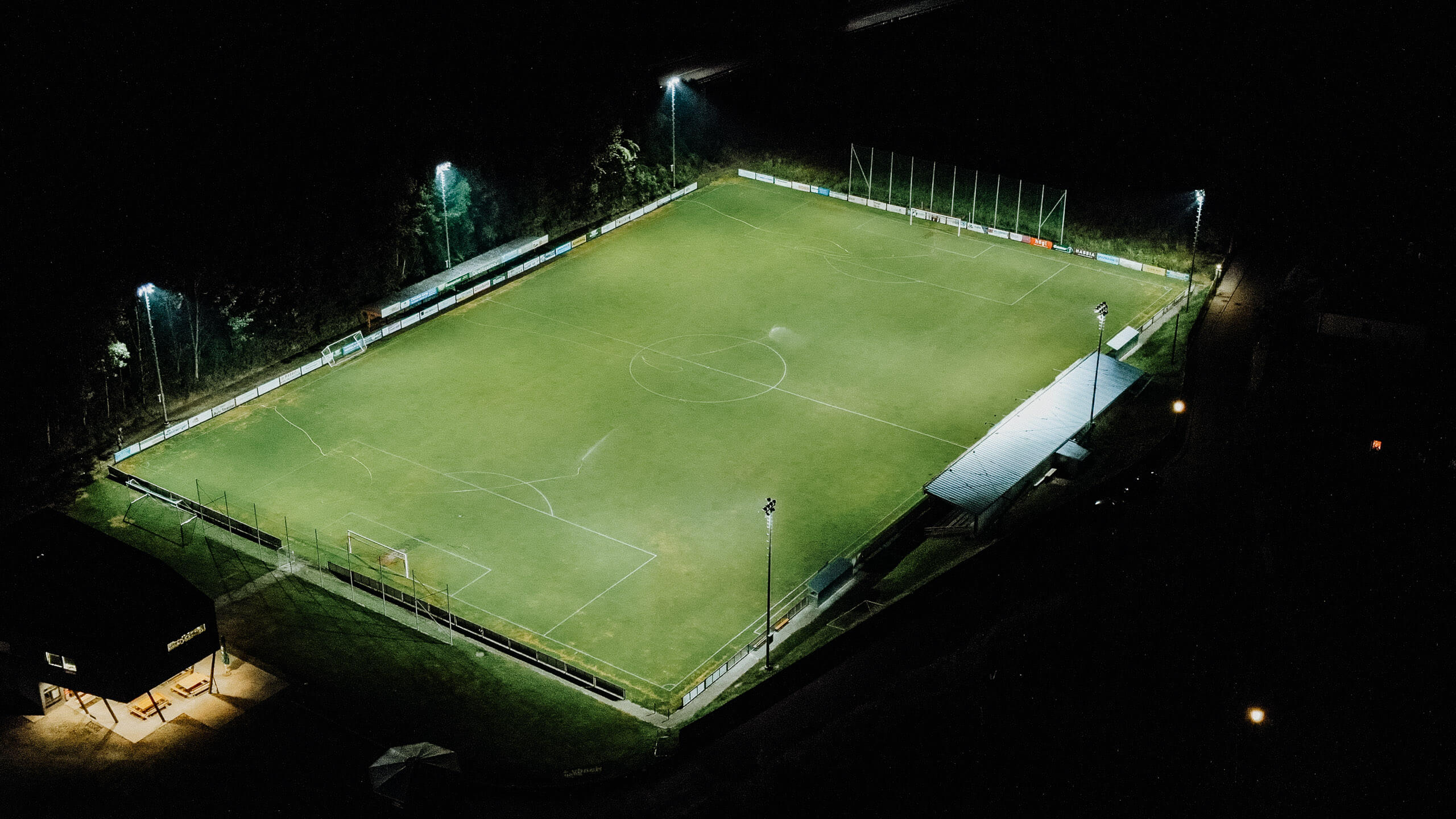 Fußballplatz mit Flutlichtanlagen bei Nacht – Beleuchtungslösungen von Illumina.