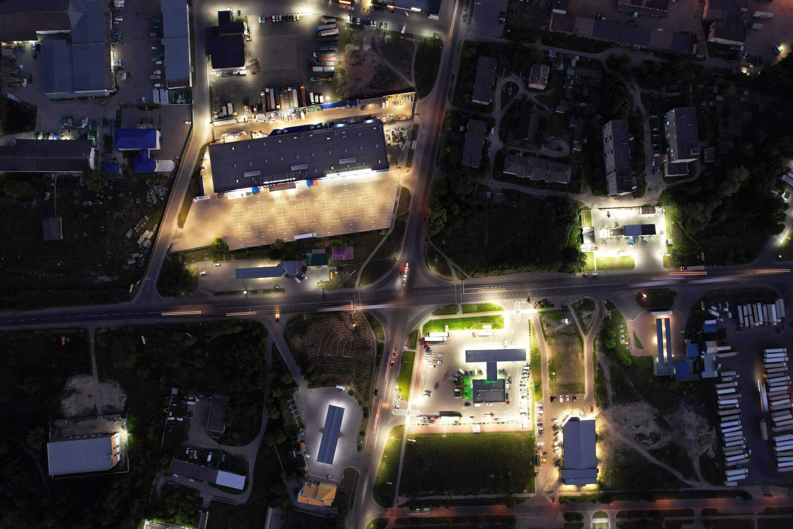 Luftaufnahme einer Stadt bei Nacht mit beleuchteter Straßenbeleuchtung und Gebäuden.