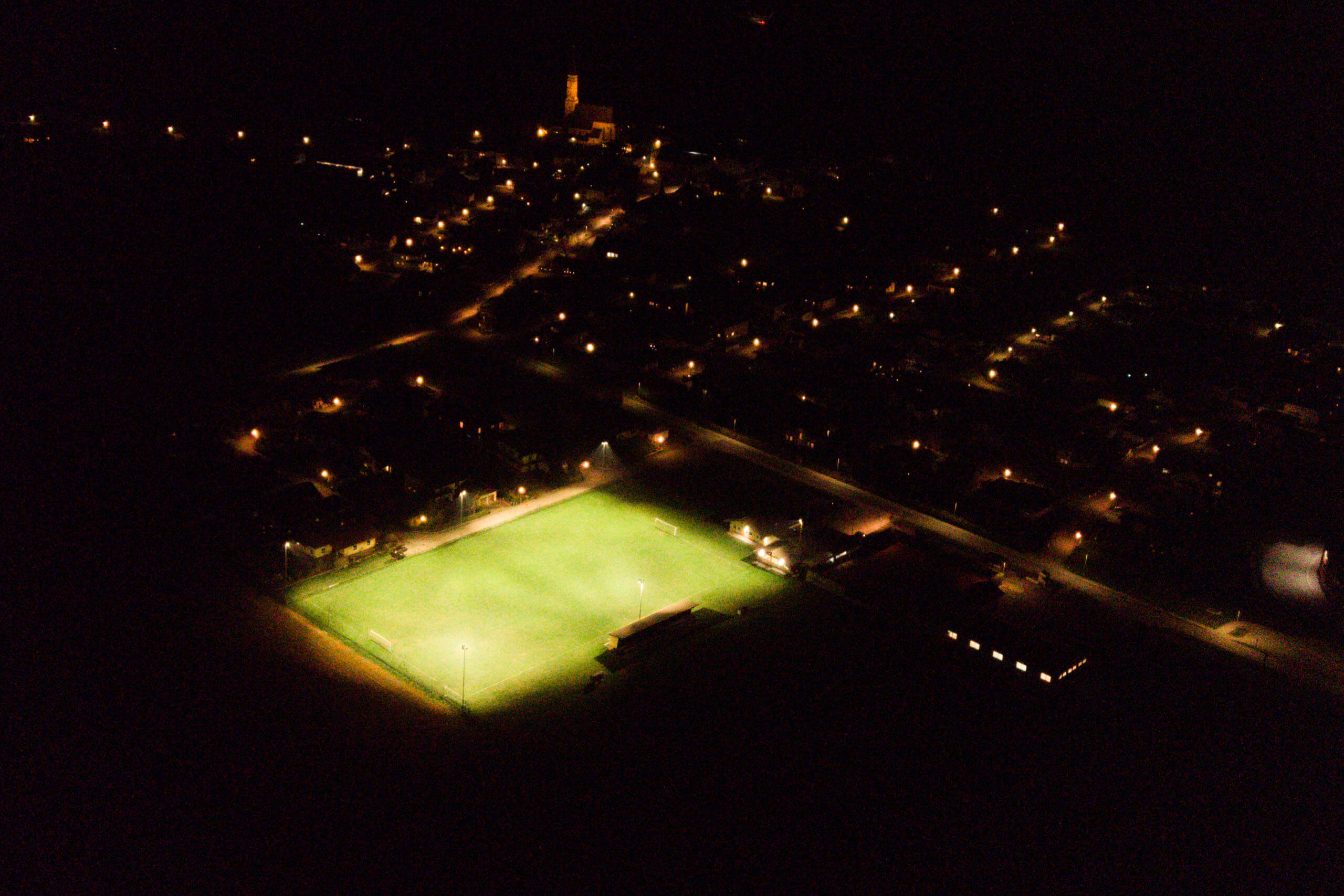 Illuminierte Sportanlage mit Fußballfeld bei Nacht – Lichtplanung von Illumina.