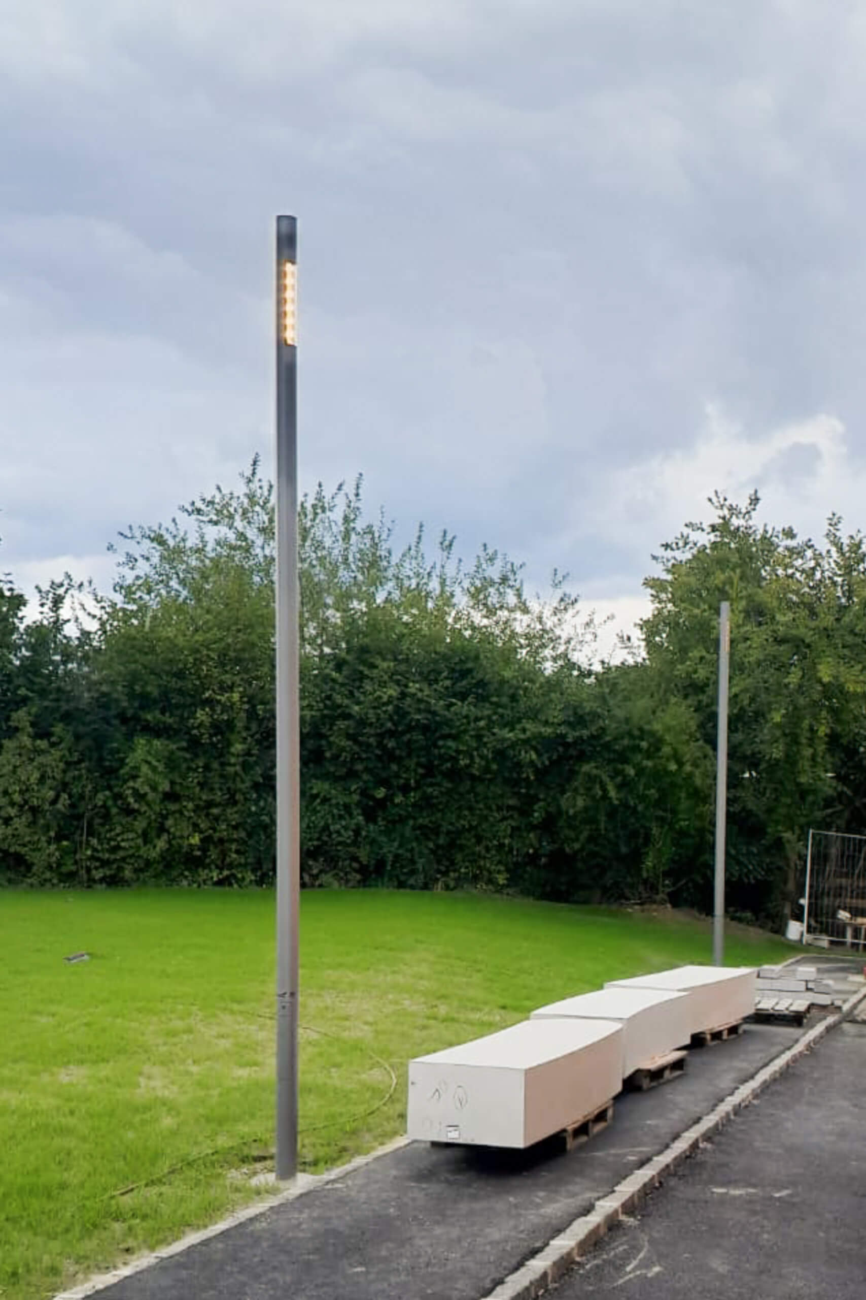 Außenbereich mit modernen Sitzbänken und Leuchten, Lichtplanung von Illumina.