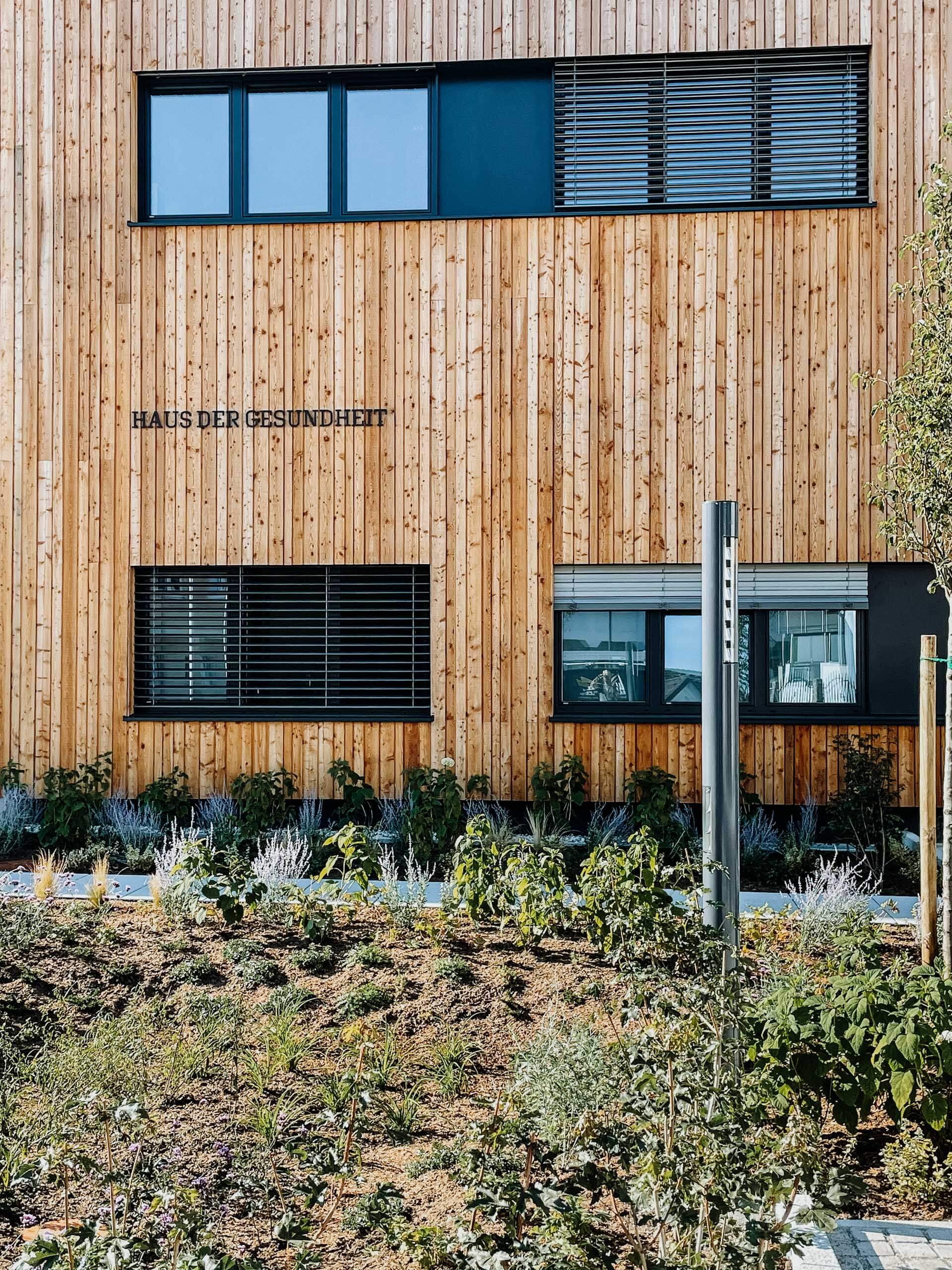 Haus der Gesundheit mit Holzfassade und Begrünung