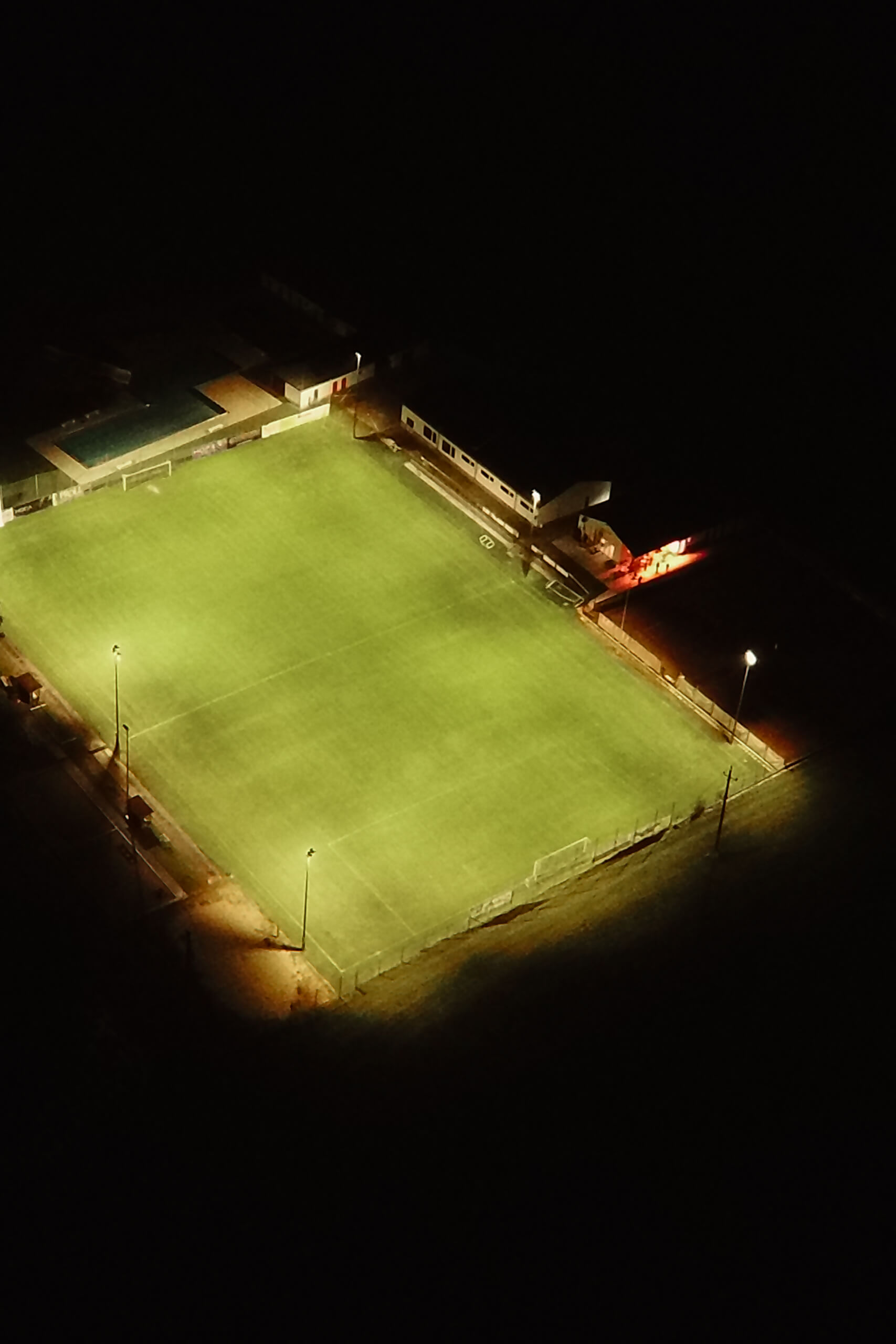 Fußballplatz bei Nacht, beleuchtet durch moderne Flutlichtanlagen von Illumina.