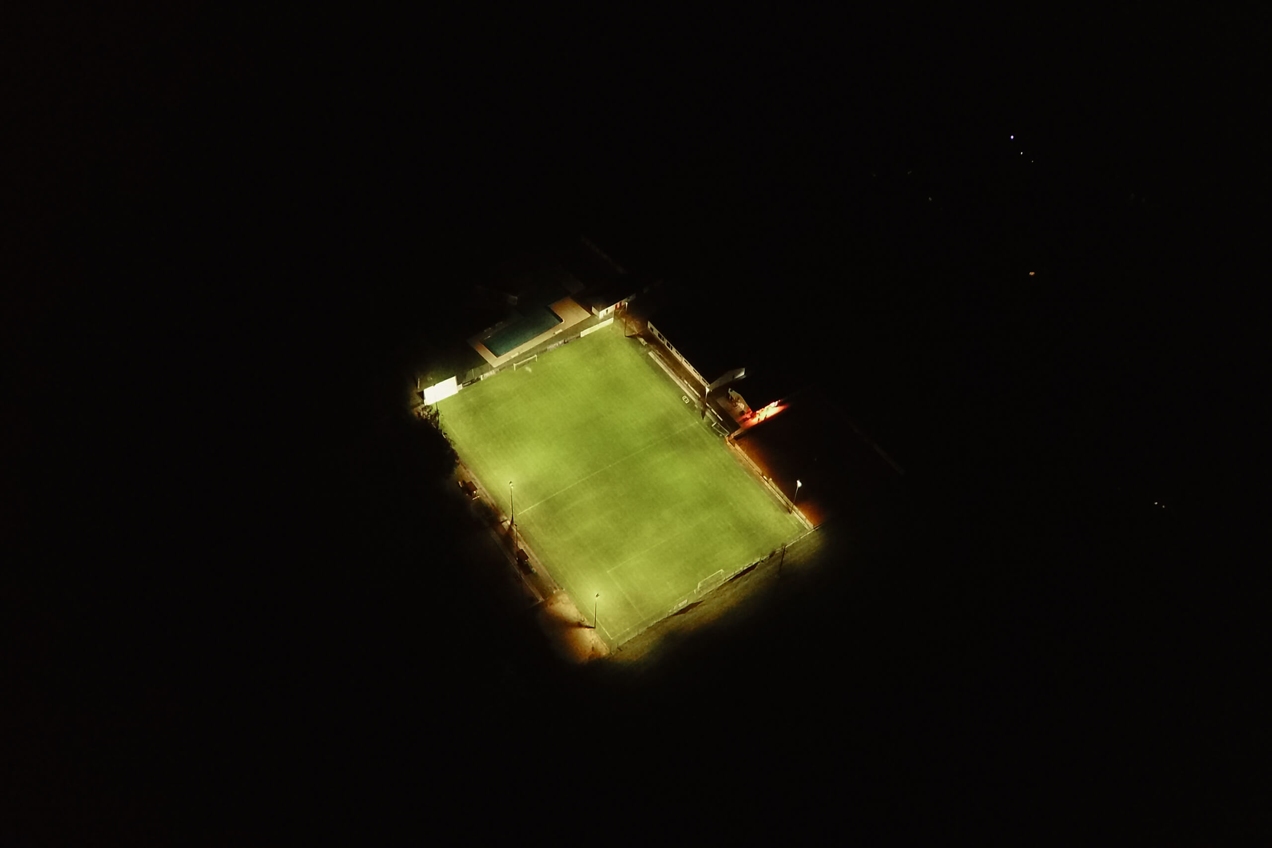 Fußballplatz bei Nacht, beleuchtet durch moderne Flutlichtanlagen