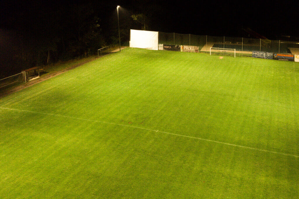 Fußballplatz bei Nacht mit heller Flutlichtbeleuchtung von Illumina