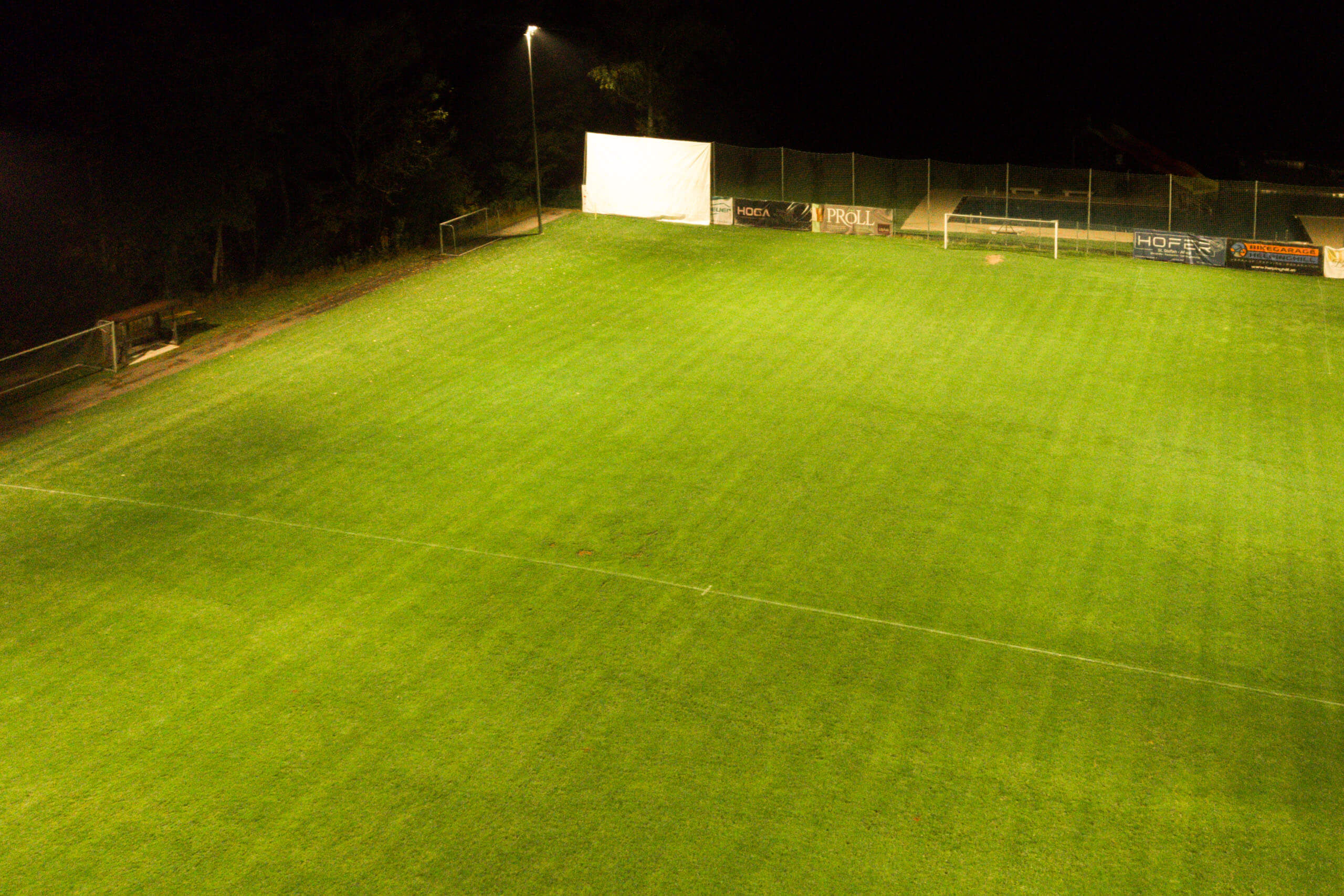 Fußballplatz bei Nacht mit heller Flutlichtbeleuchtung von Illumina
