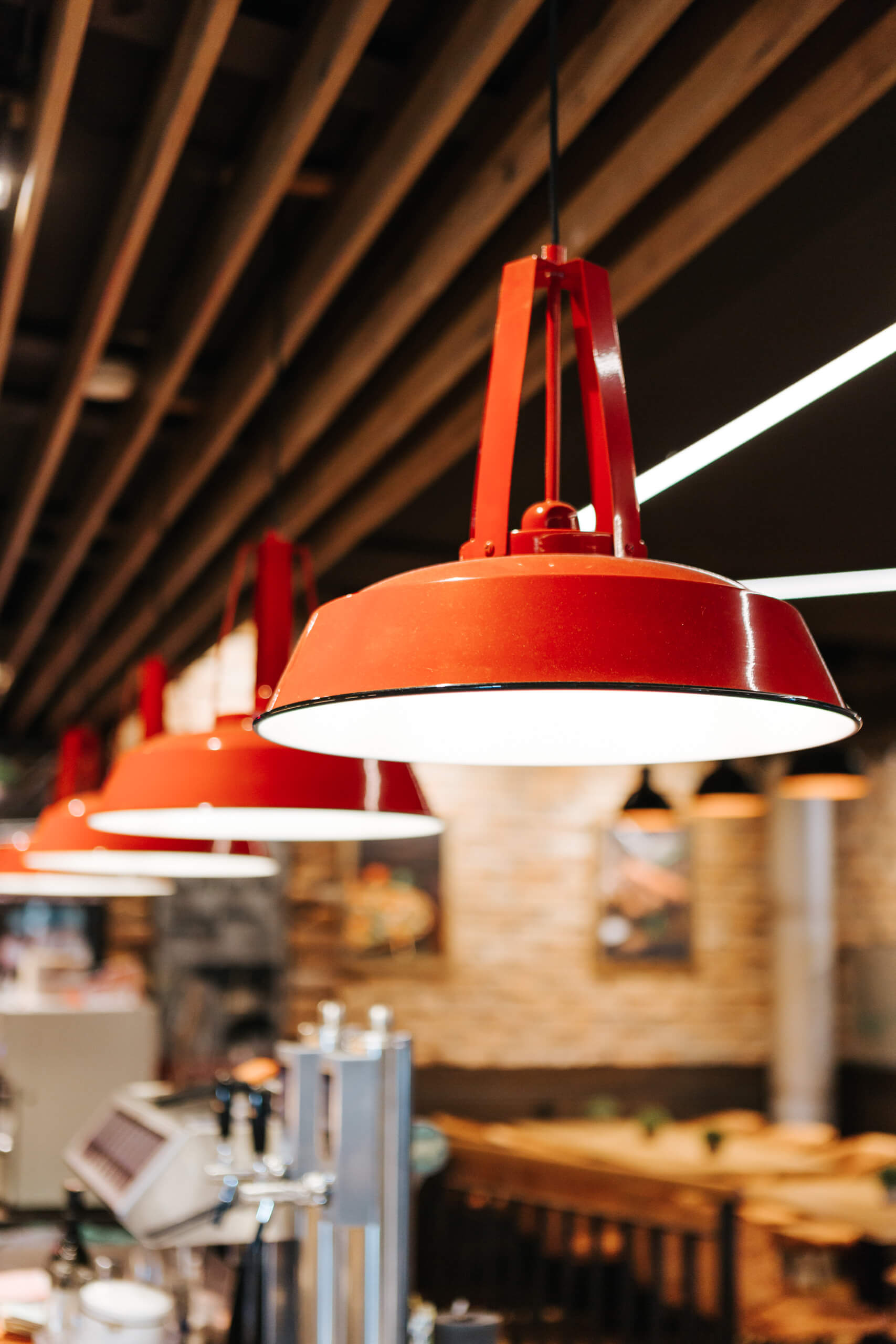 Reihe von roten Pendelleuchten über einer Theke in einem Restaurant.