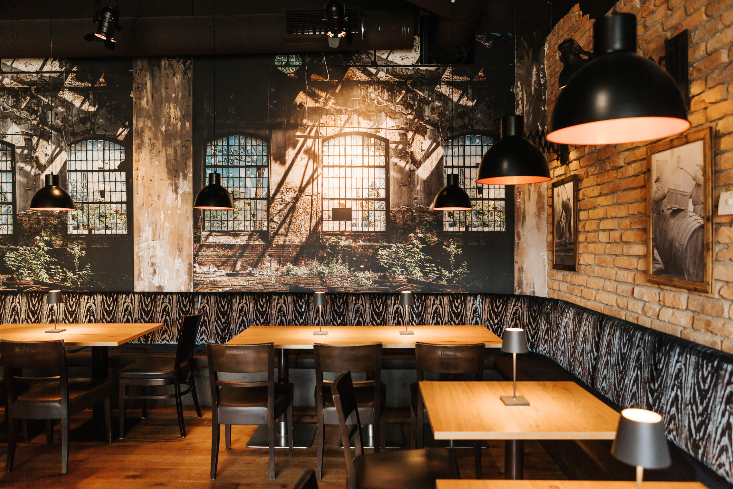 Restaurant-Interieur mit industriellem Wandbild und Hängeleuchten von Illumina.