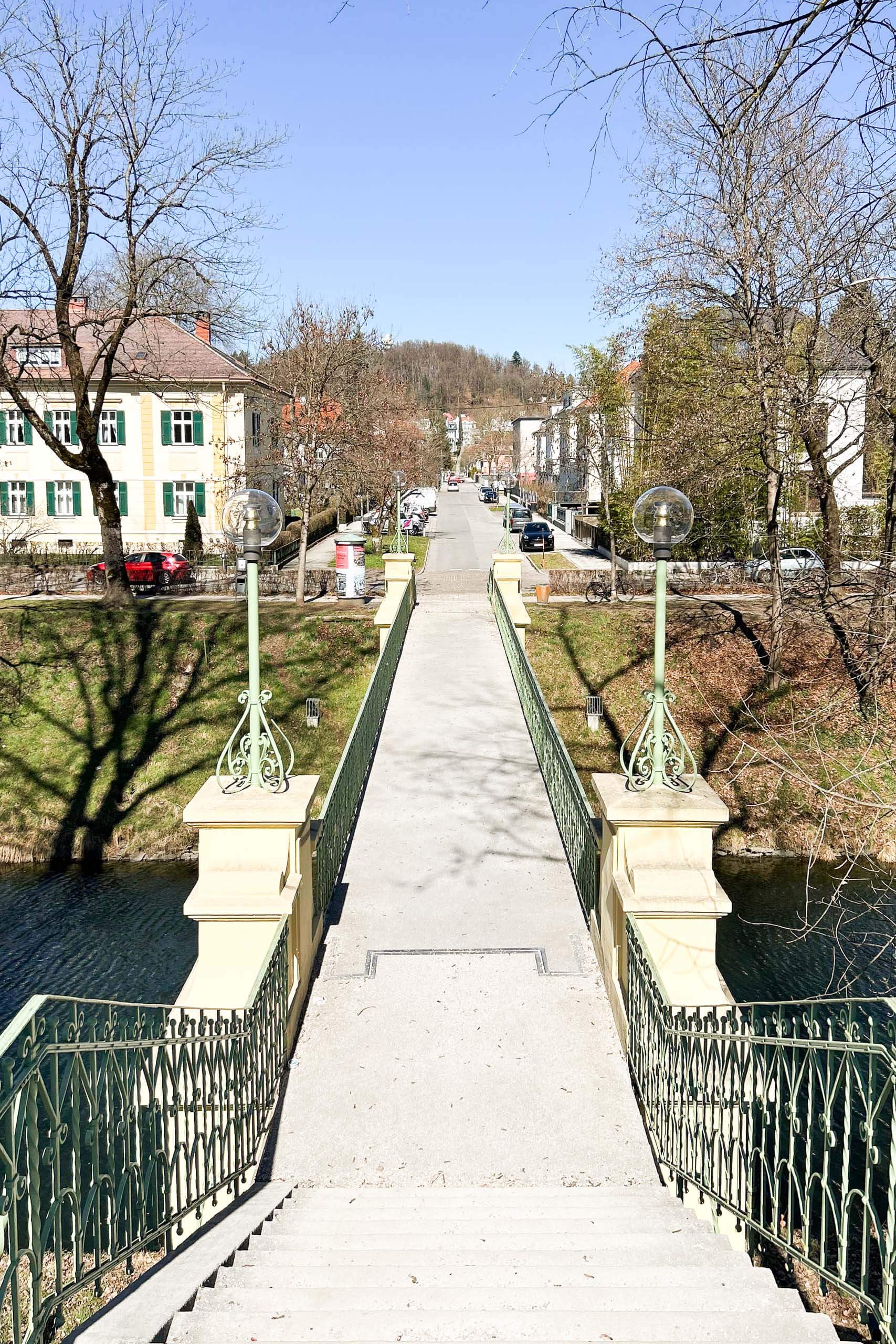 Brücke mit Laternen und Blick auf eine Straße in einer Stadt.