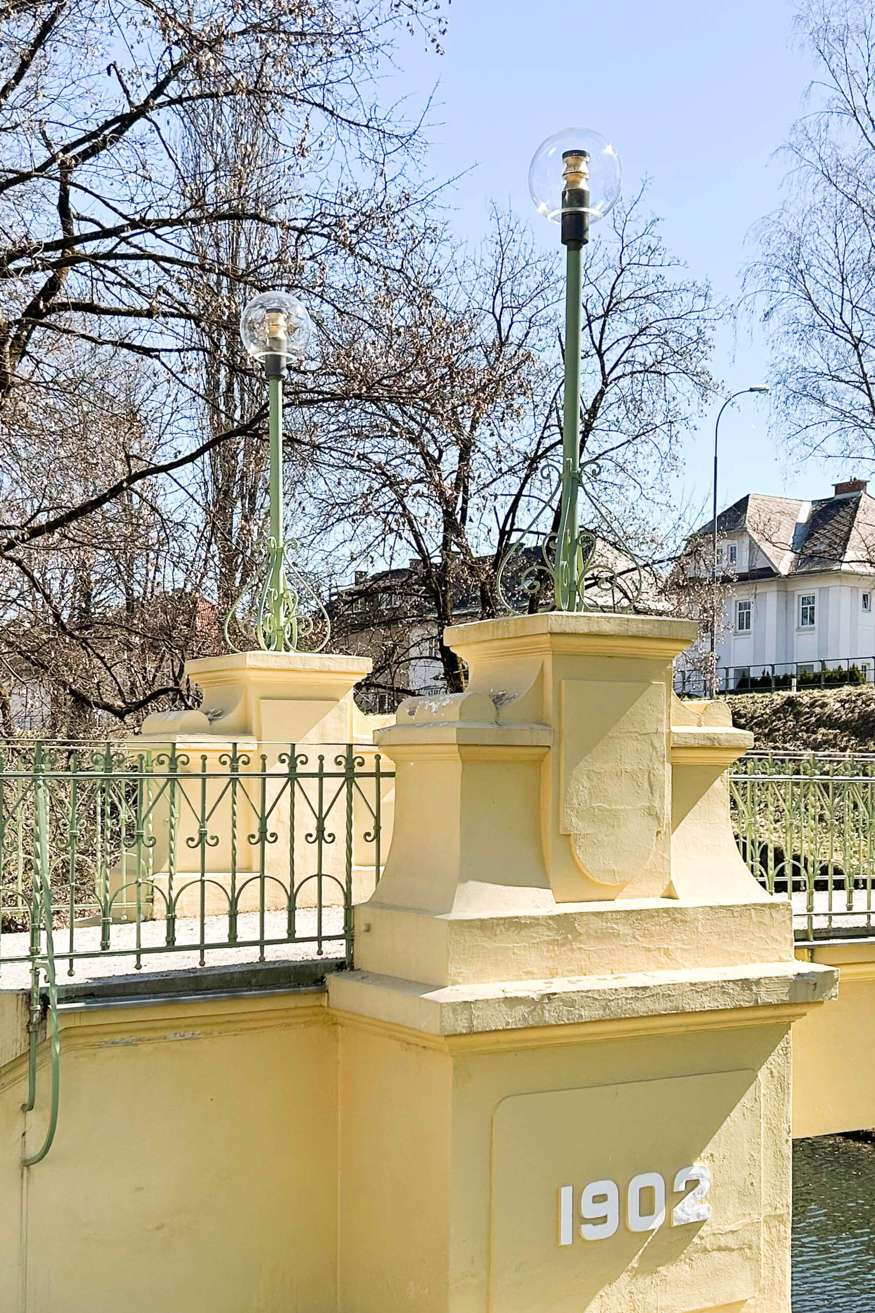 Gelbe Brückenpfeiler mit der Jahreszahl 1902, Laternen und schmiedeeisernem Geländer