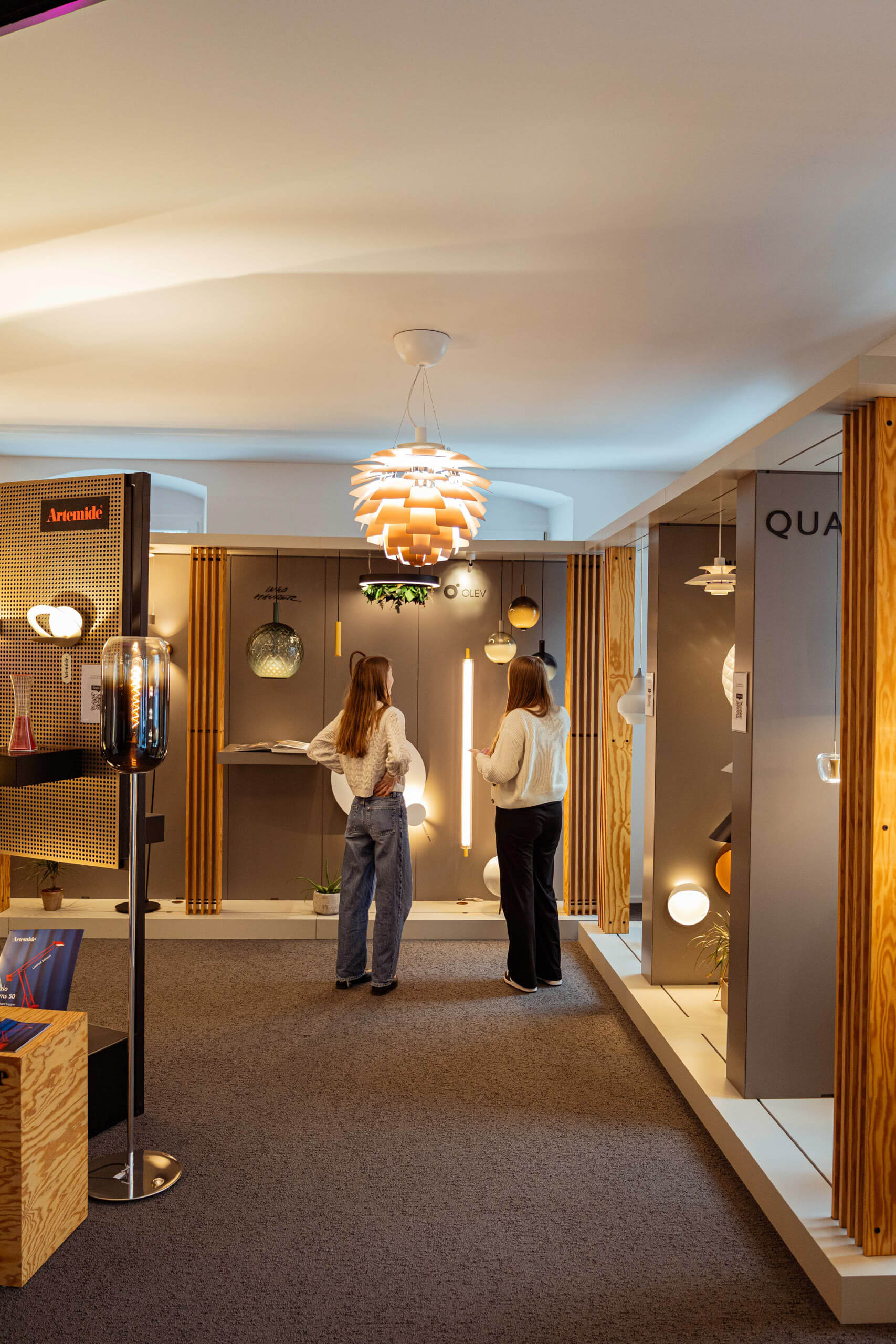 Lichtplanung in einem Showroom mit modernen Leuchten und zwei Kundinnen.