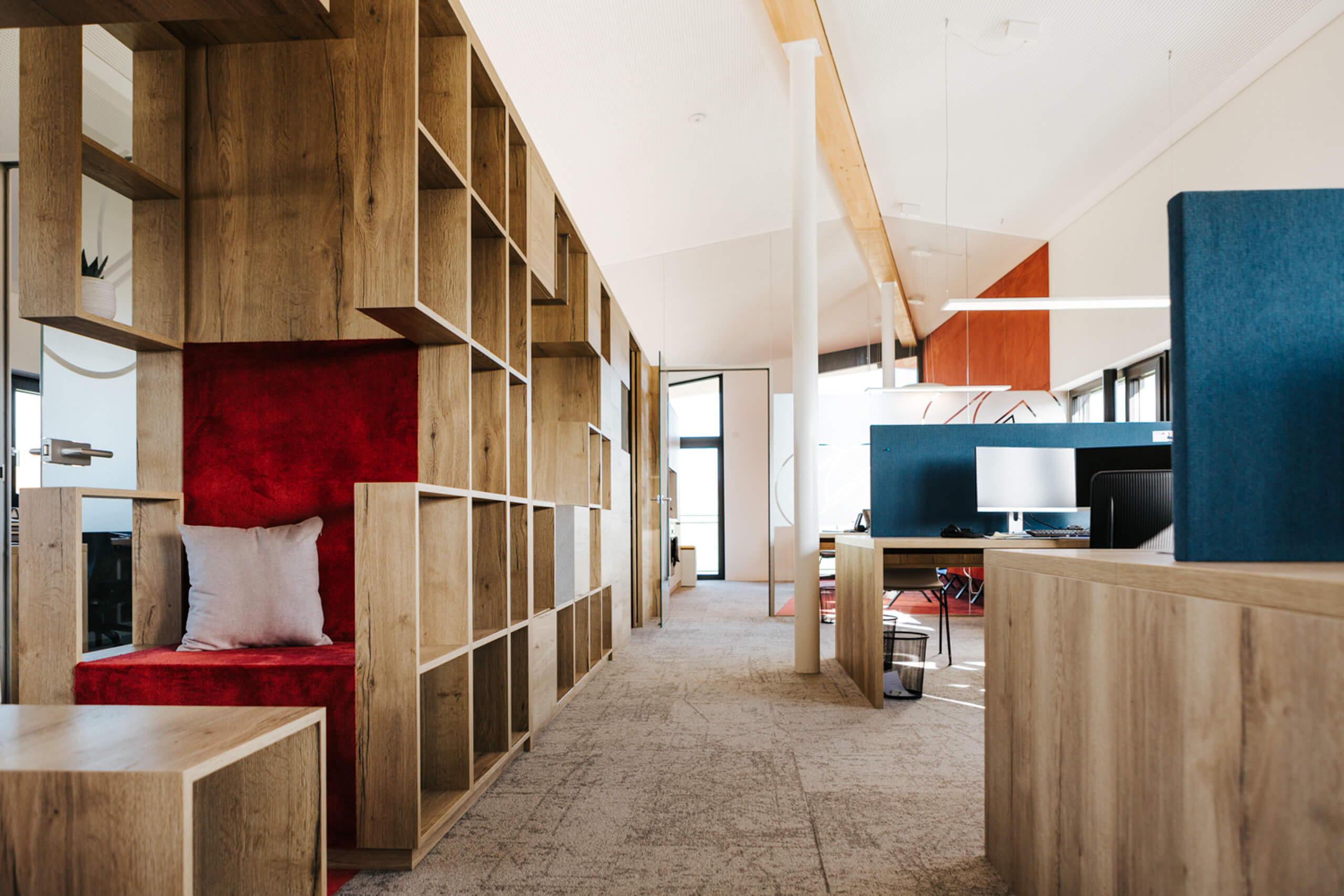 Moderne Büroeinrichtung mit Holzelementen und Sitznische.