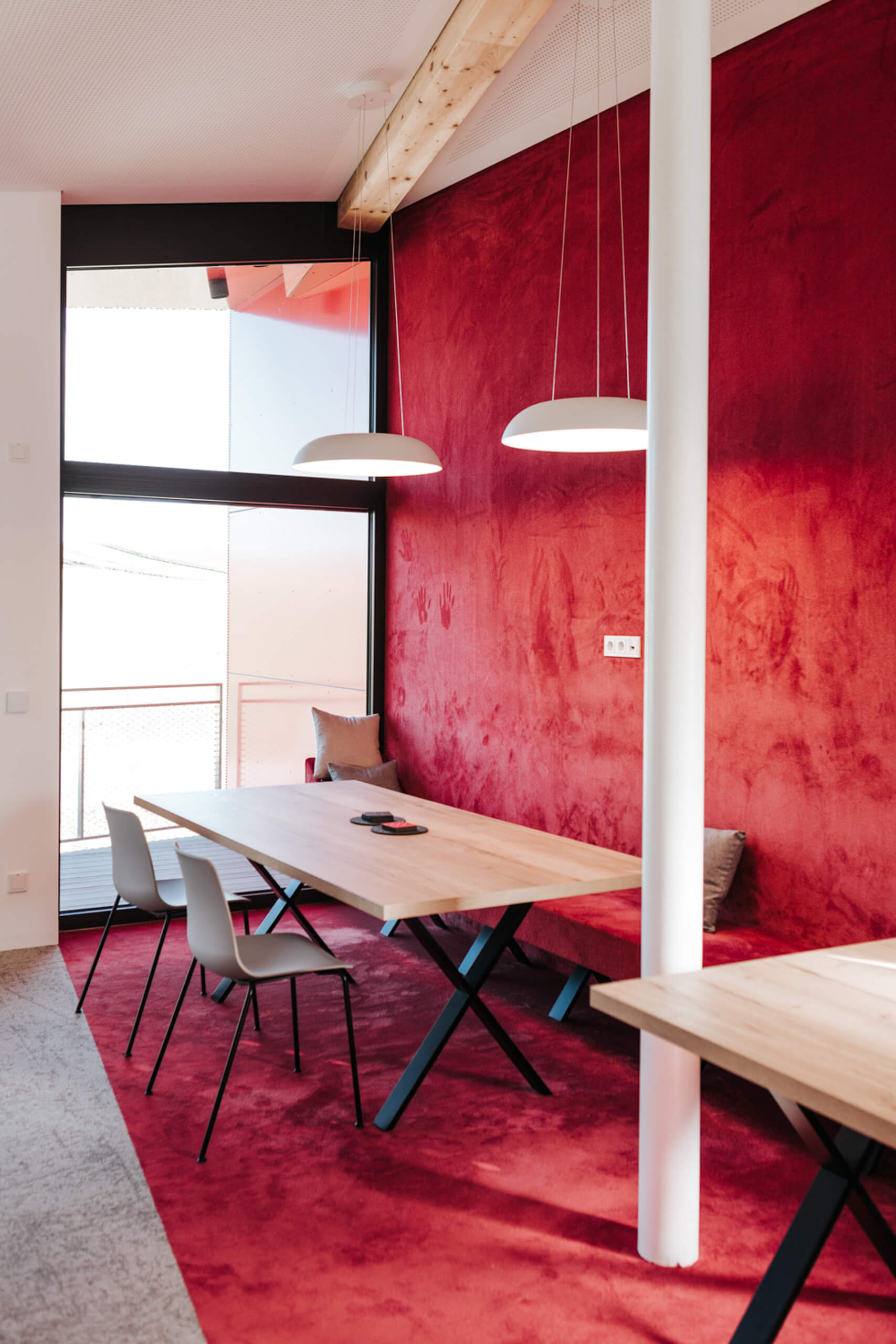 Moderne Besprechungsraum-Beleuchtung mit roter Wandgestaltung und Hängeleuchten von Illumina