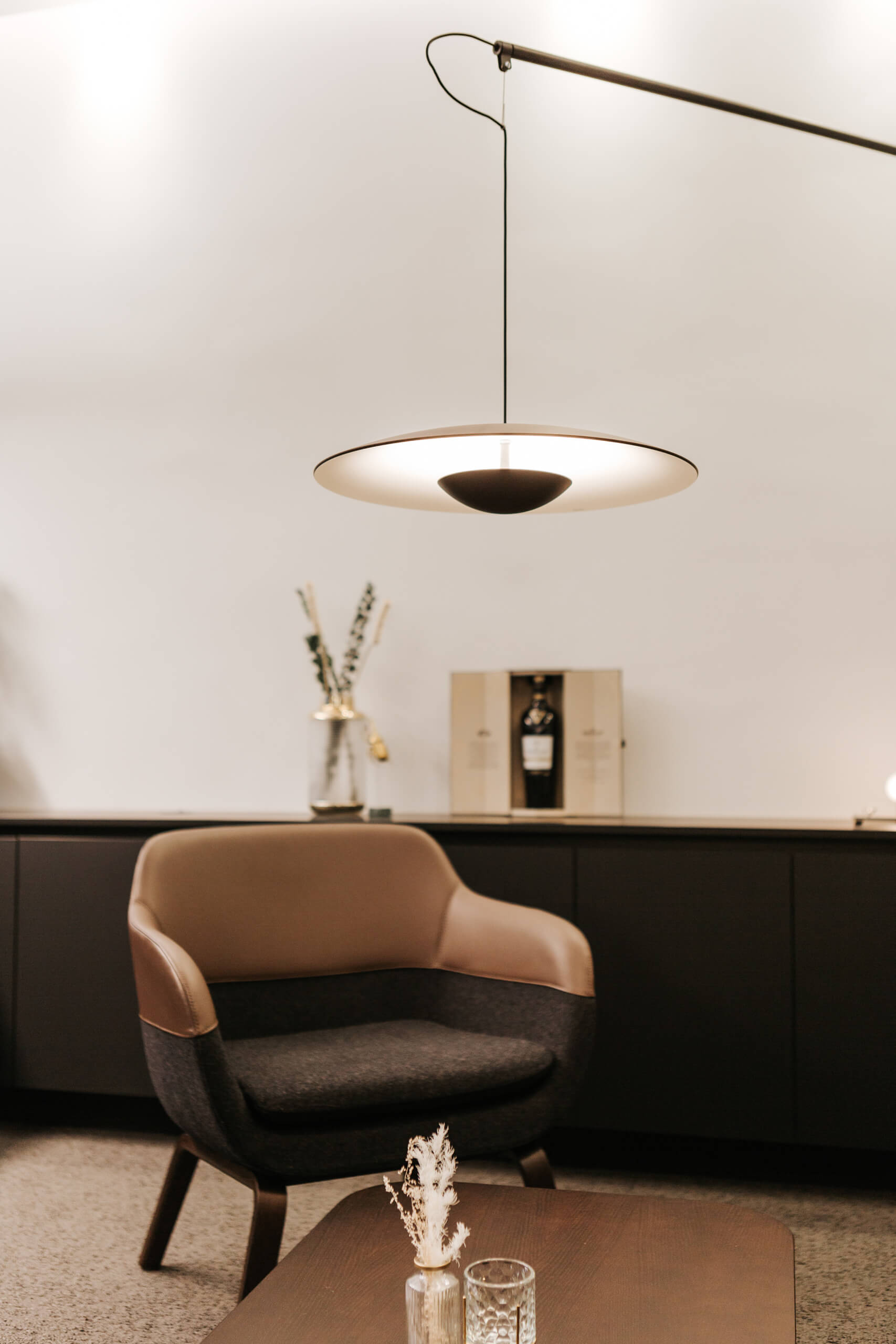Gemütliche Sitzecke in einem Lichtstudio mit moderner Hängeleuchte.