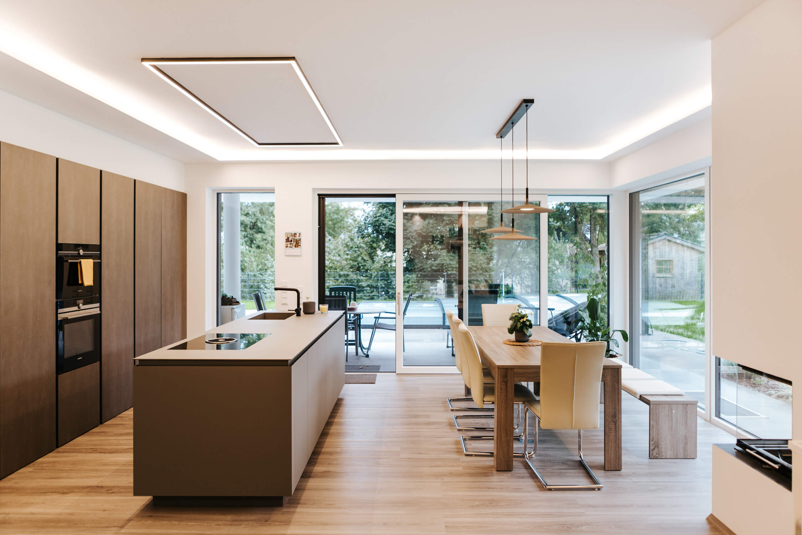 Moderne Küche mit Essbereich und indirekter Beleuchtung – Lichtplanung von Illumina.
