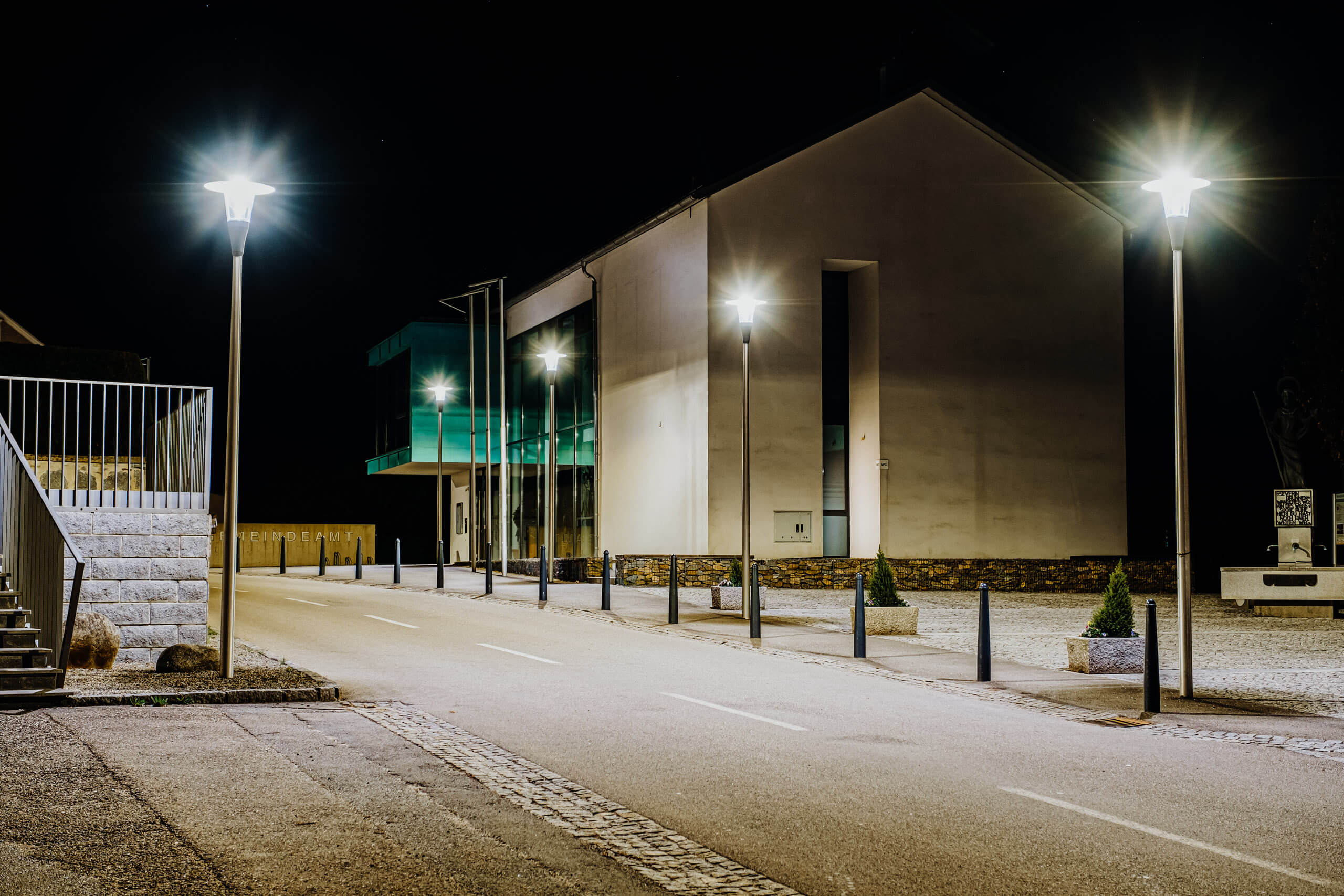 Moderne Straßenbeleuchtung vor einem Gebäude bei Nacht