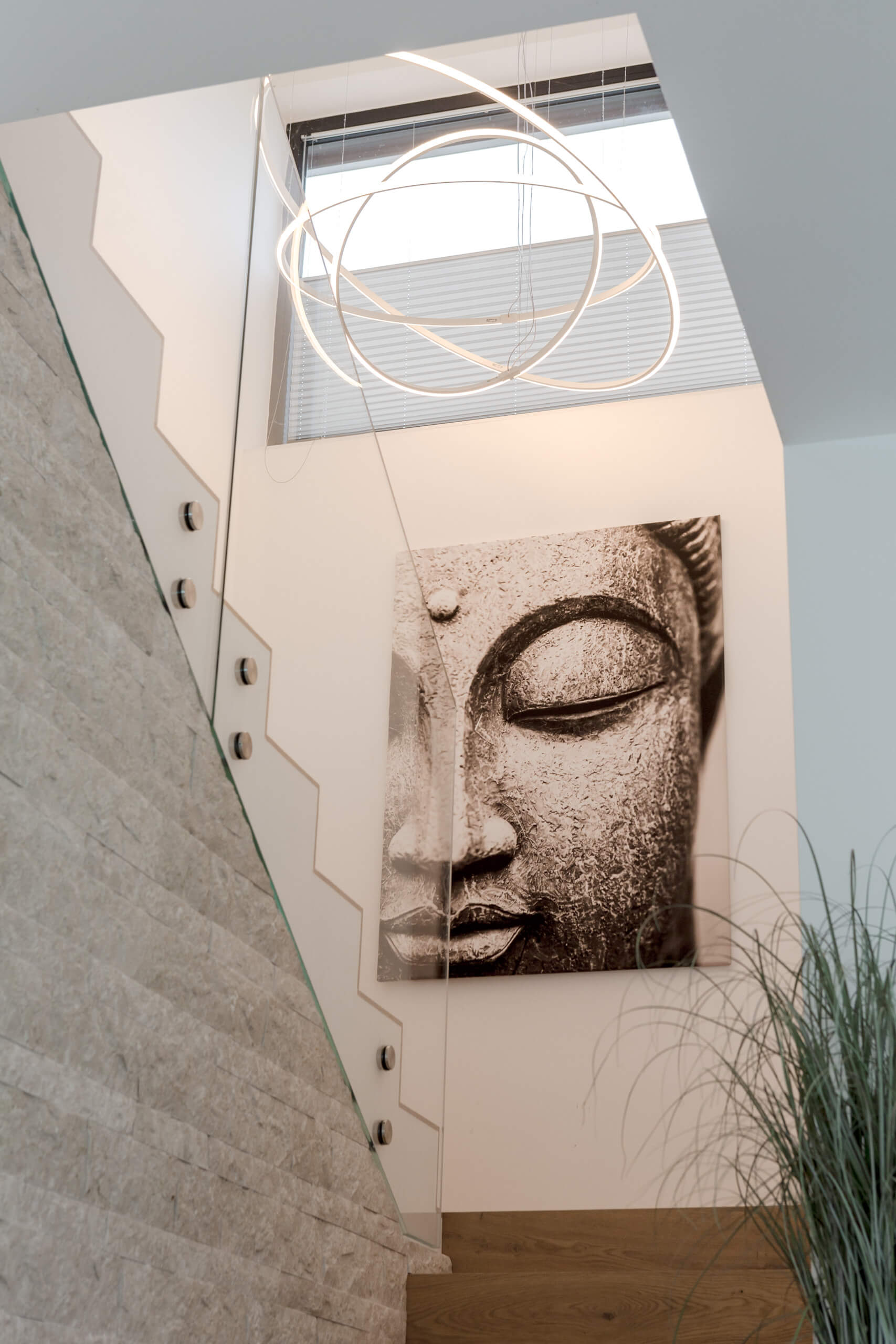 Moderne Treppe mit Buddha-Bild und Ring-Pendelleuchte – Förderberatung Beleuchtung