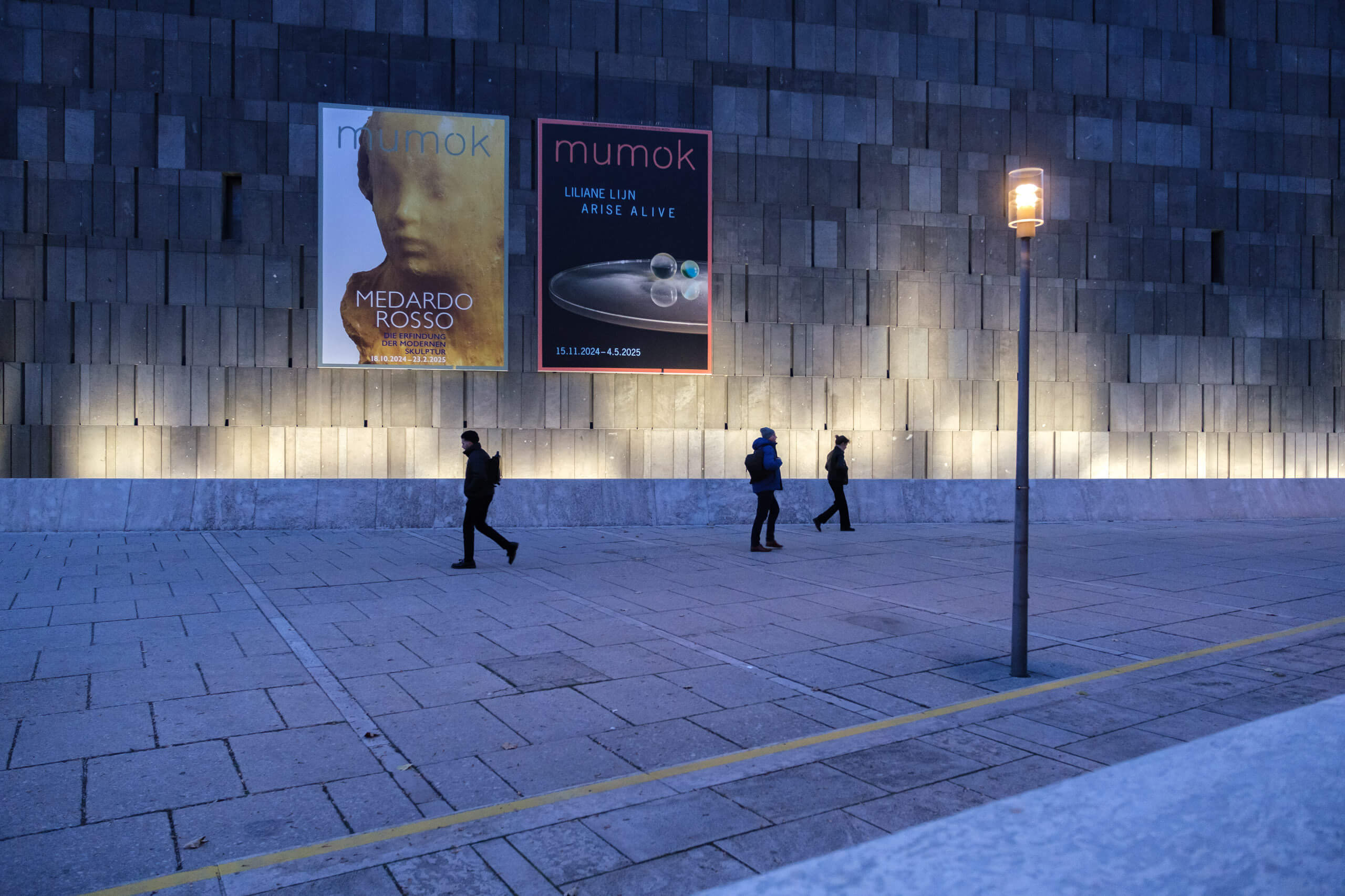 Ortsplatzgestaltung mit moderner Beleuchtung und Kunstplakaten am Abend