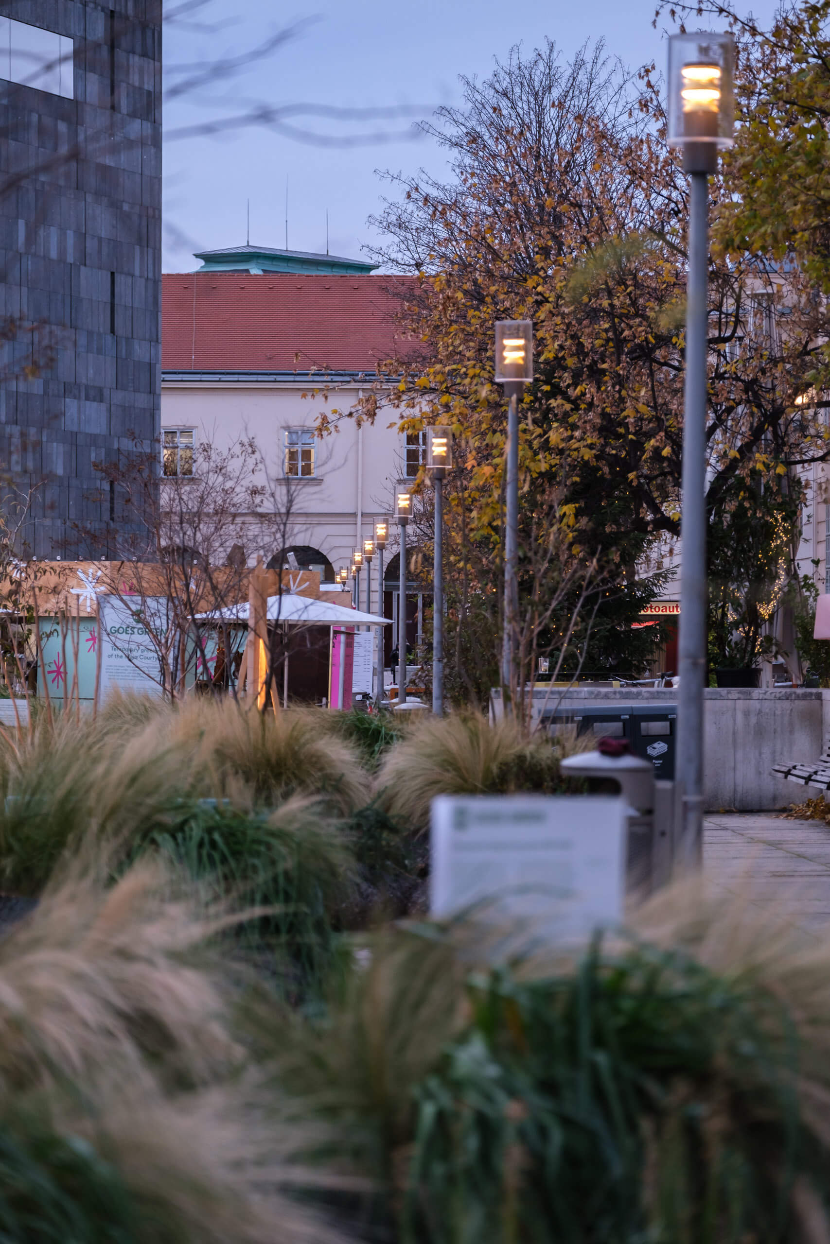 Beleuchtete Wege und Gebäude in Wien, Österreich, im Abendlicht.
