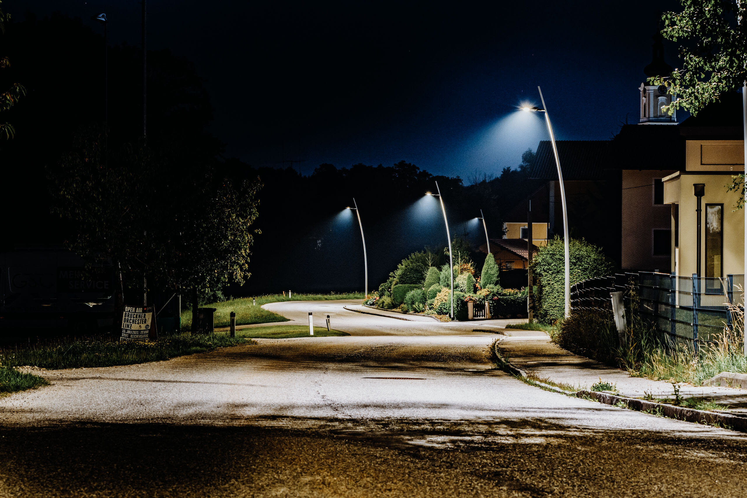 Straßenbeleuchtung beleuchtet eine ruhige Gasse bei Nacht.