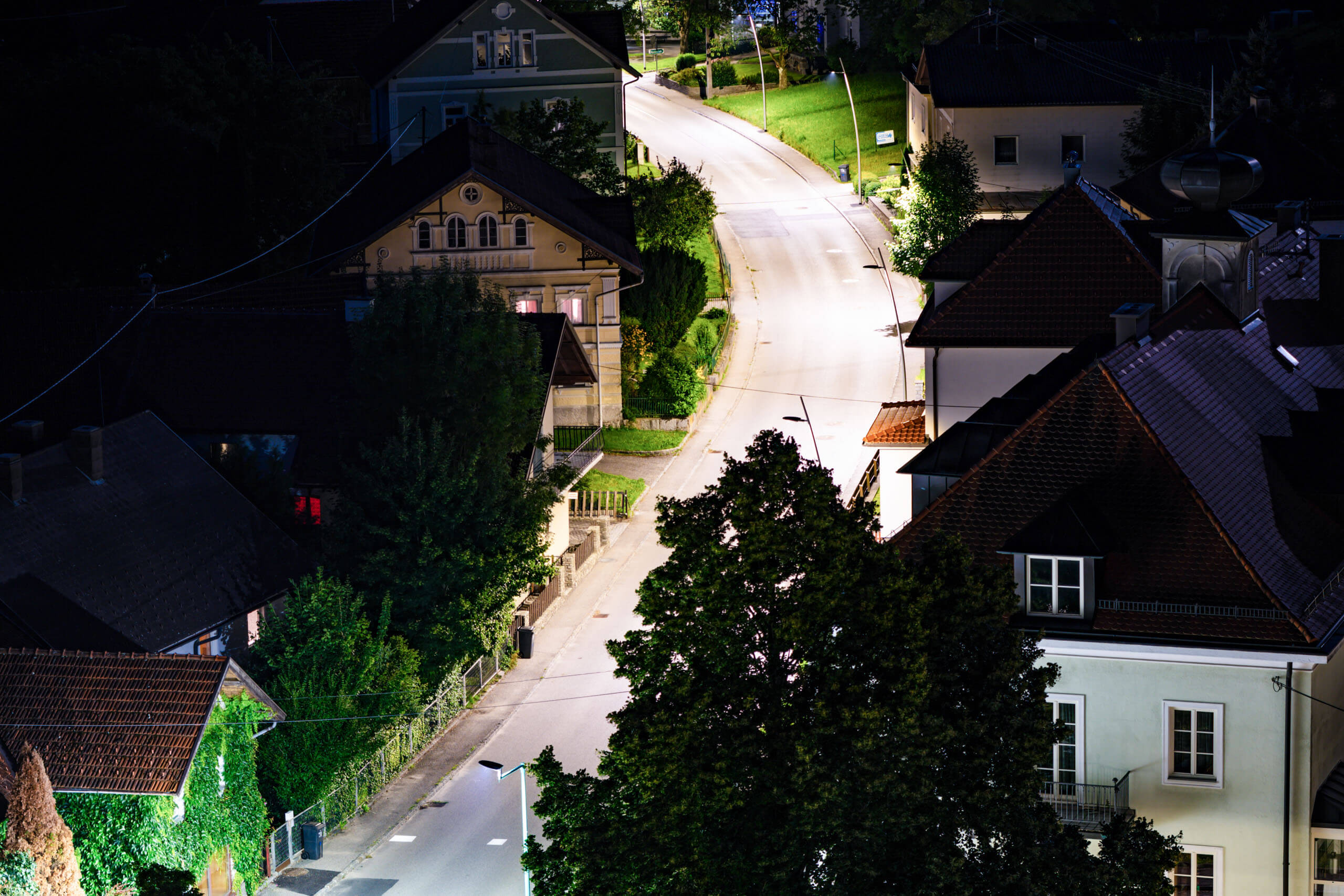 Straßenbeleuchtung in einem ruhigen Dorf bei Nacht, beleuchtet von Illumina.