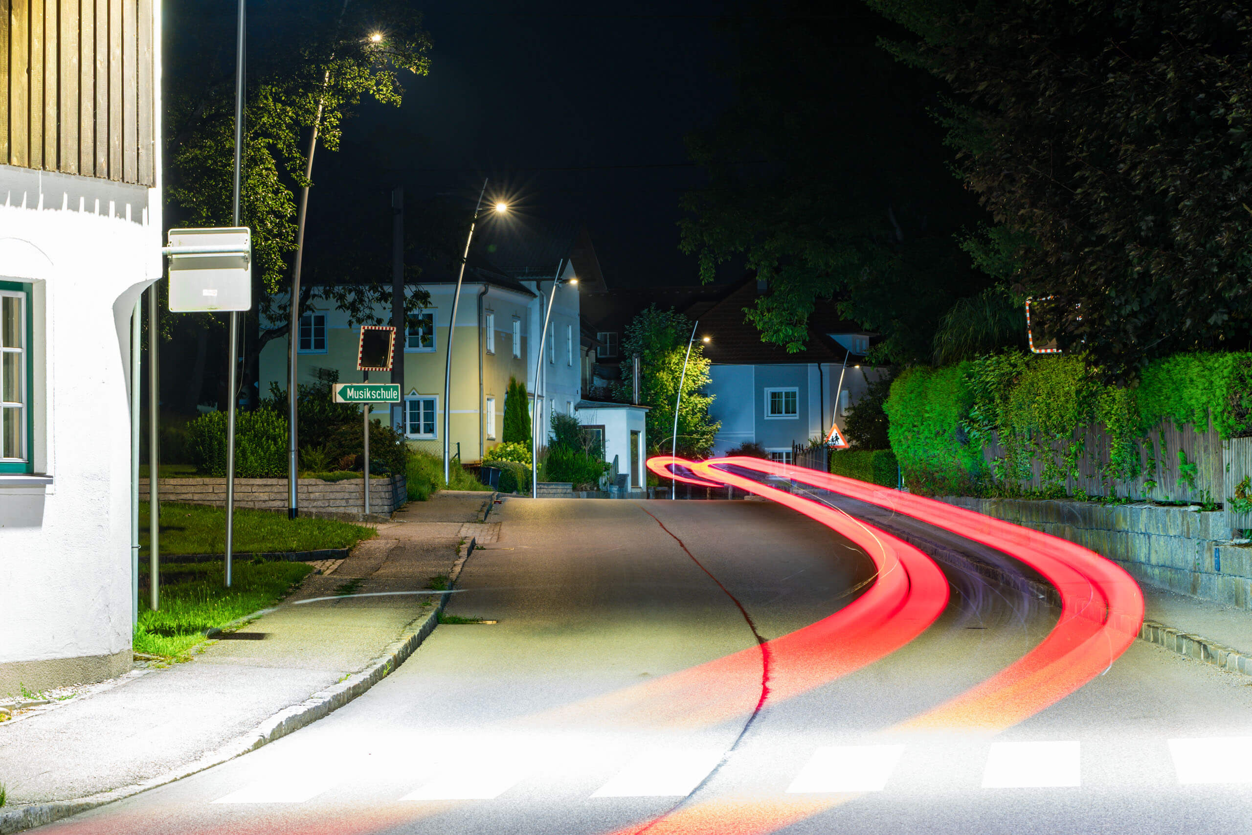 Straßenbeleuchtung und Lichtspuren bei Nacht in einer Wohngegend