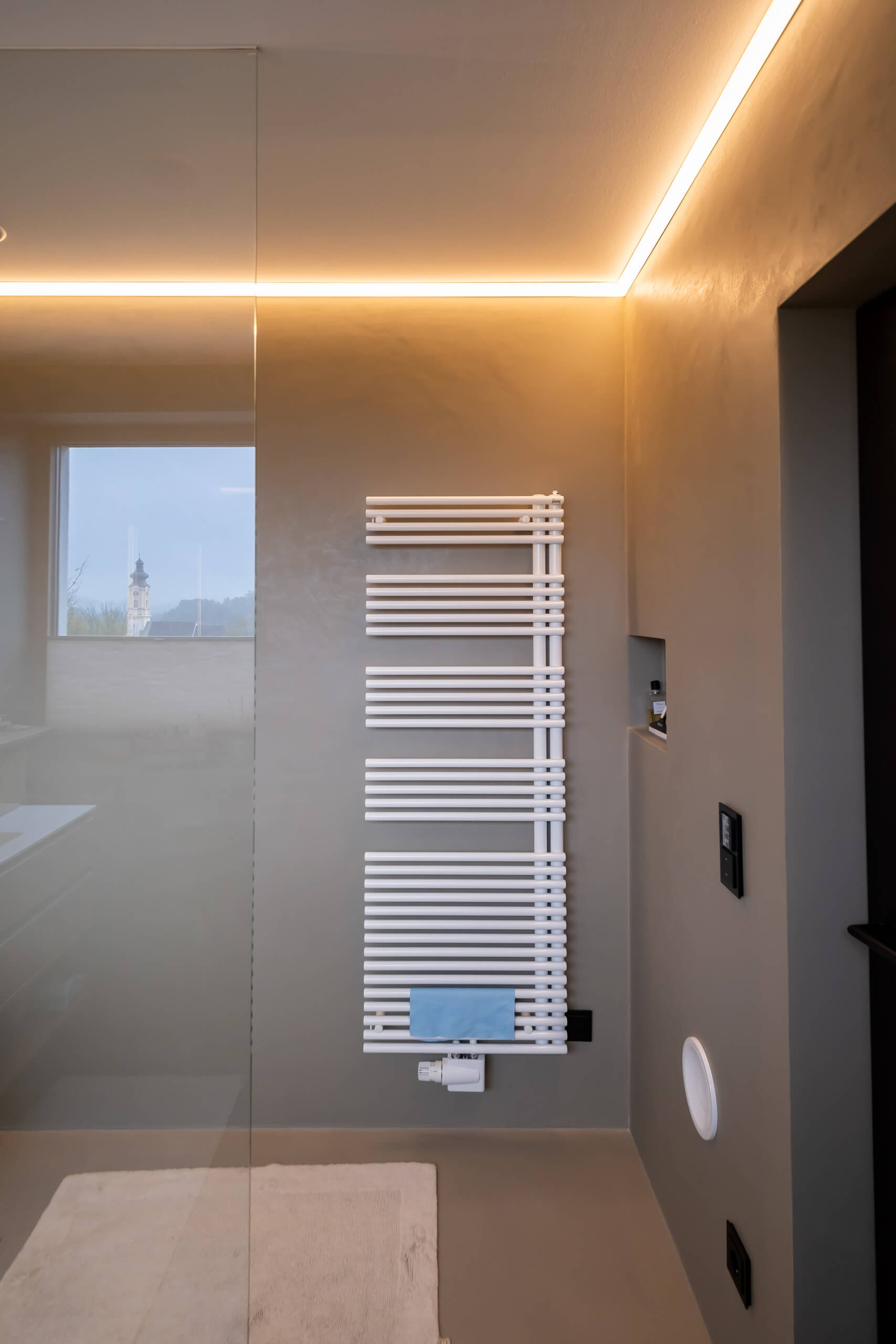 Modernes Badezimmer mit Handtuchwärmer und indirekter Beleuchtung
