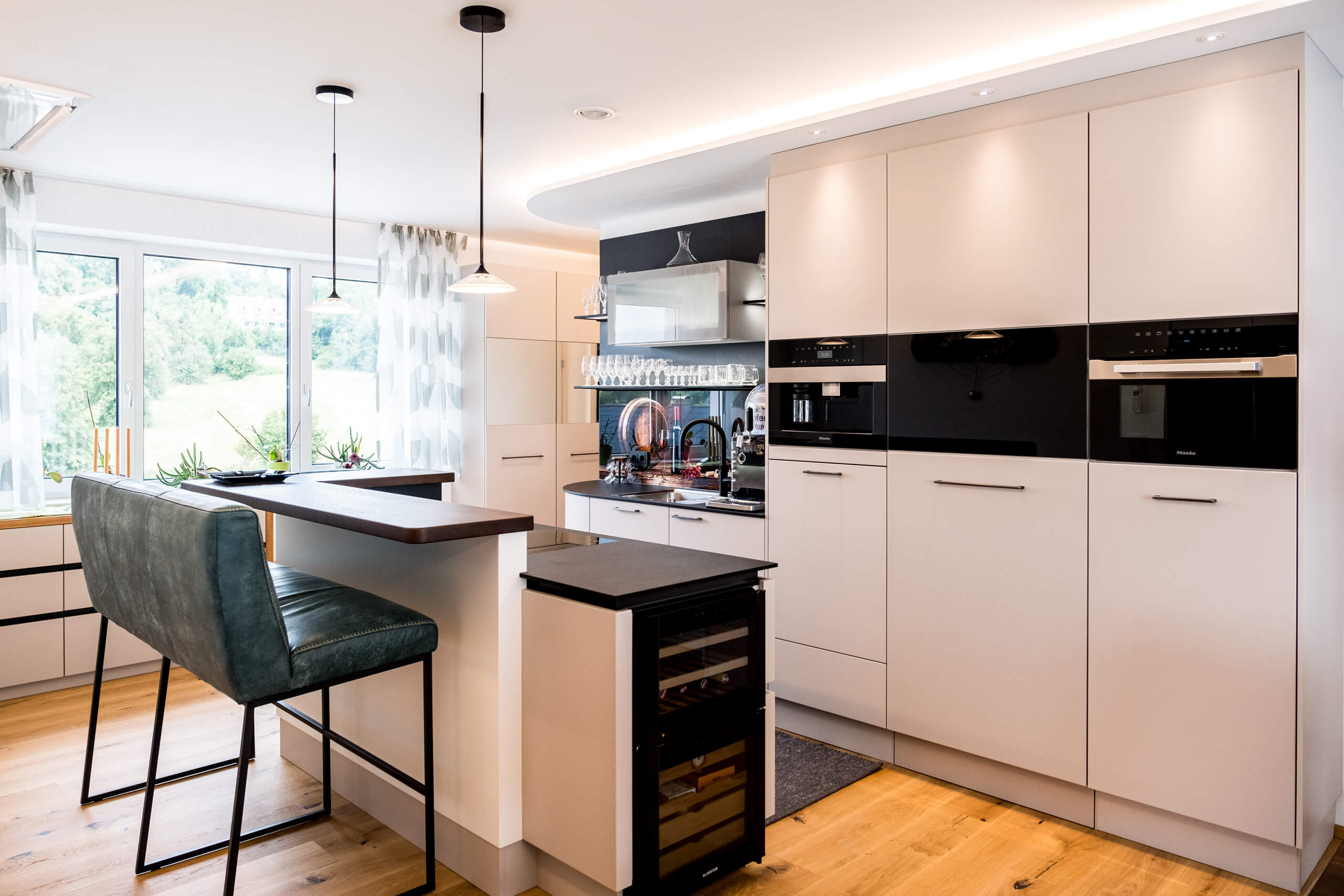 Moderne Küche mit Kochinsel, Bar und Wein-Kühlschrank – Lichtplanung von Illumina.