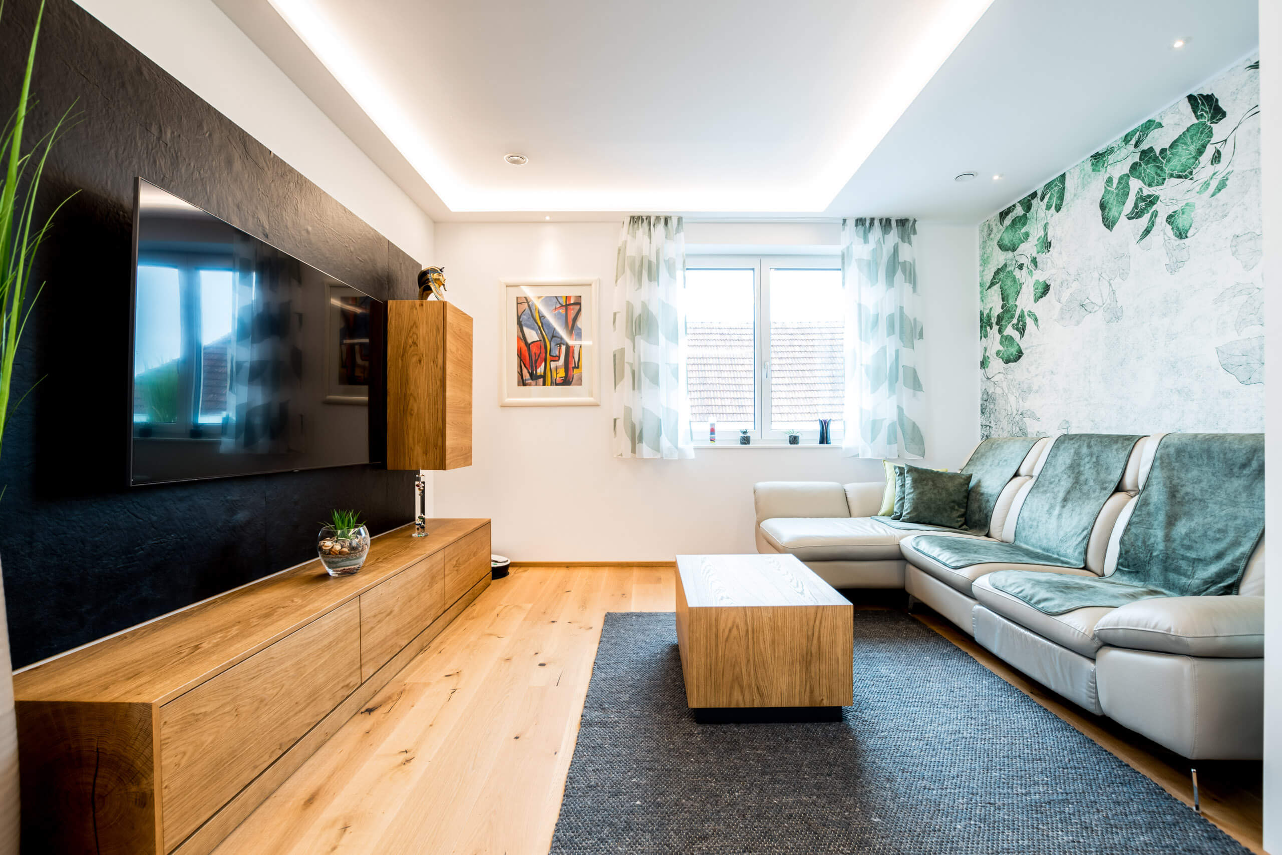 Modernes Wohnzimmer mit heller Beleuchtung und Pflanzenakzenten, Lichtplanung von Illumina.