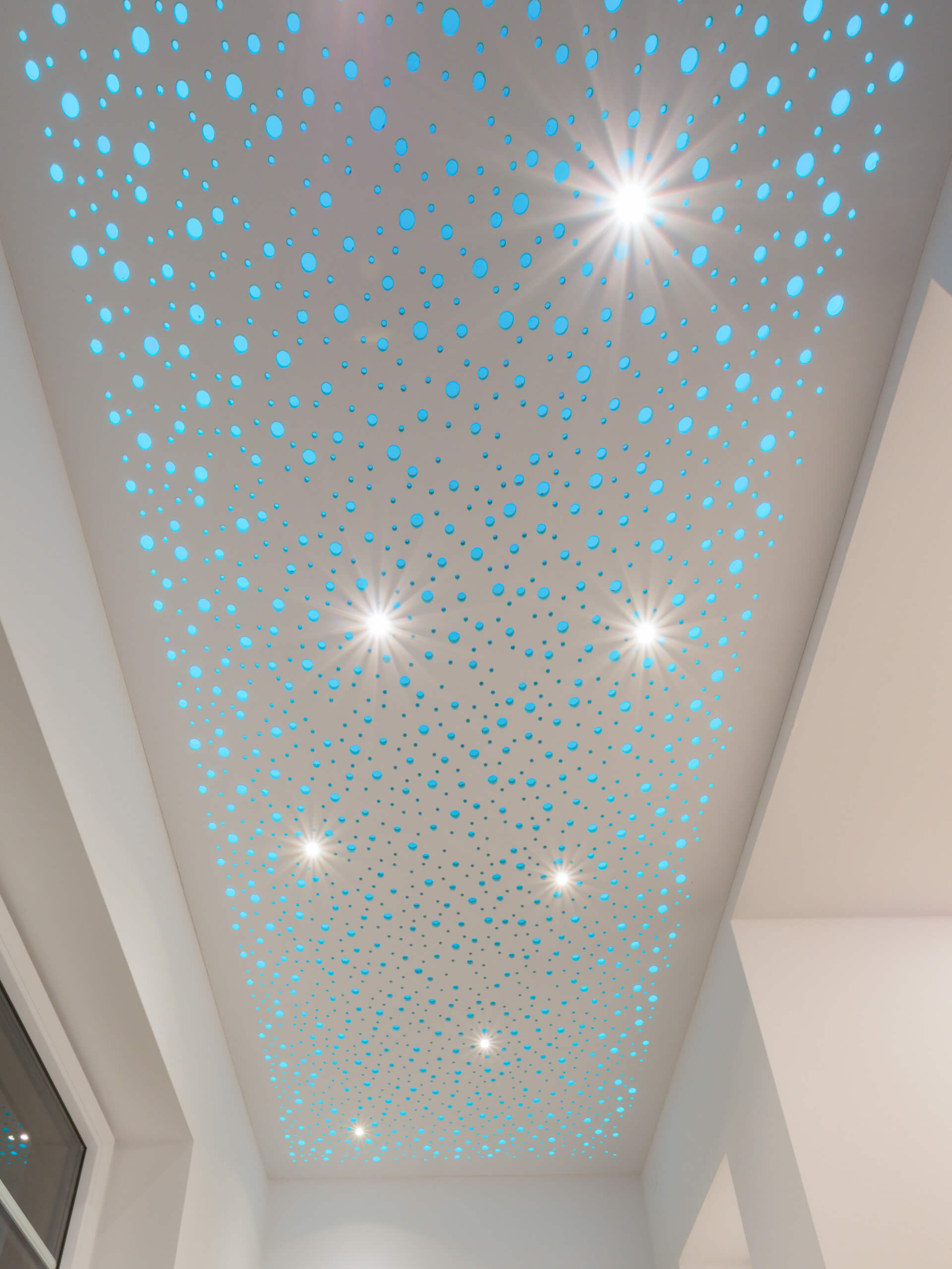 Deckenbeleuchtung mit blauen Sternen und Spots in einem modernen Raum