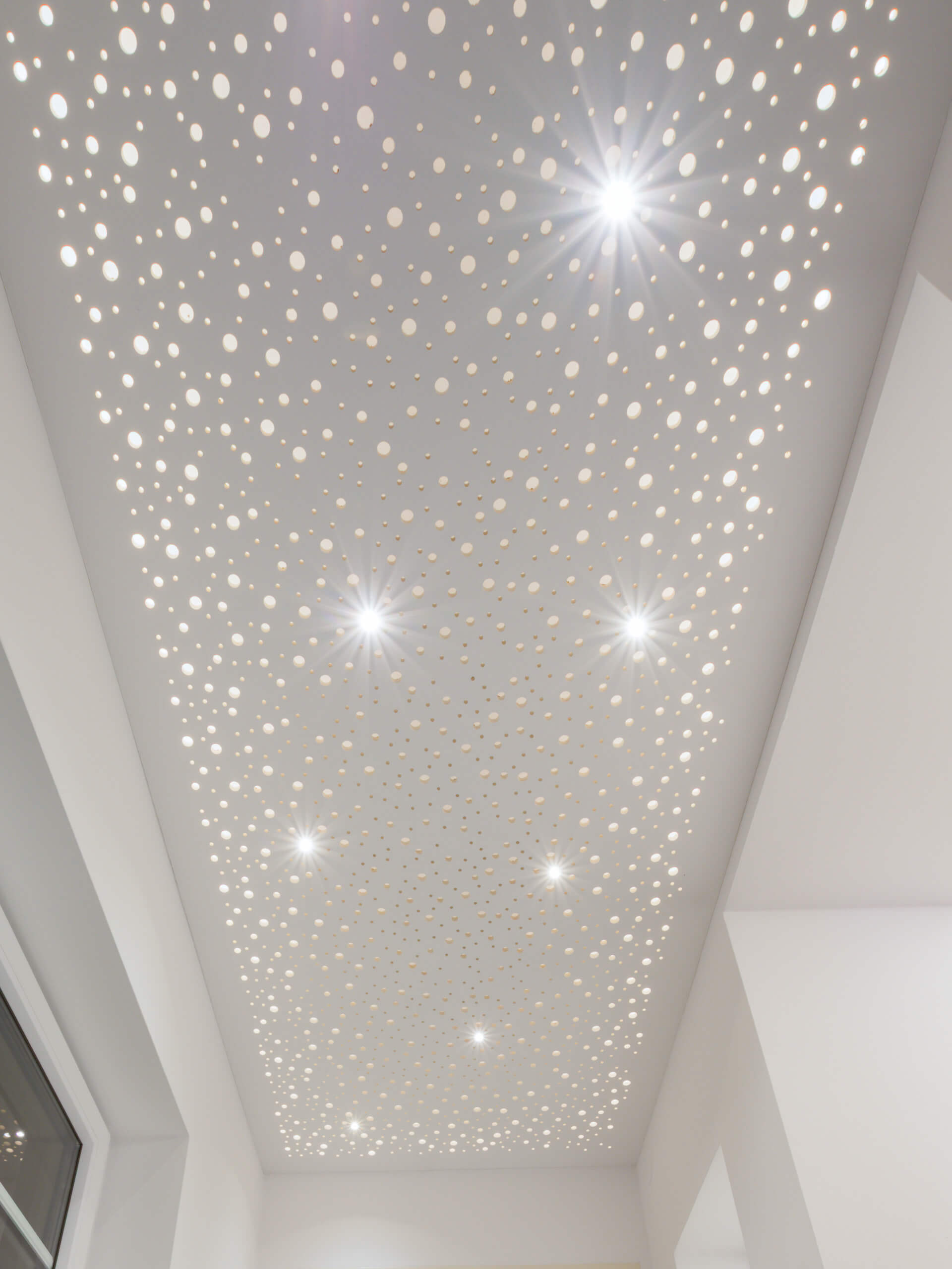 Deckenbeleuchtung mit Lochmuster und integrierten Spots für stimmungsvolles Licht