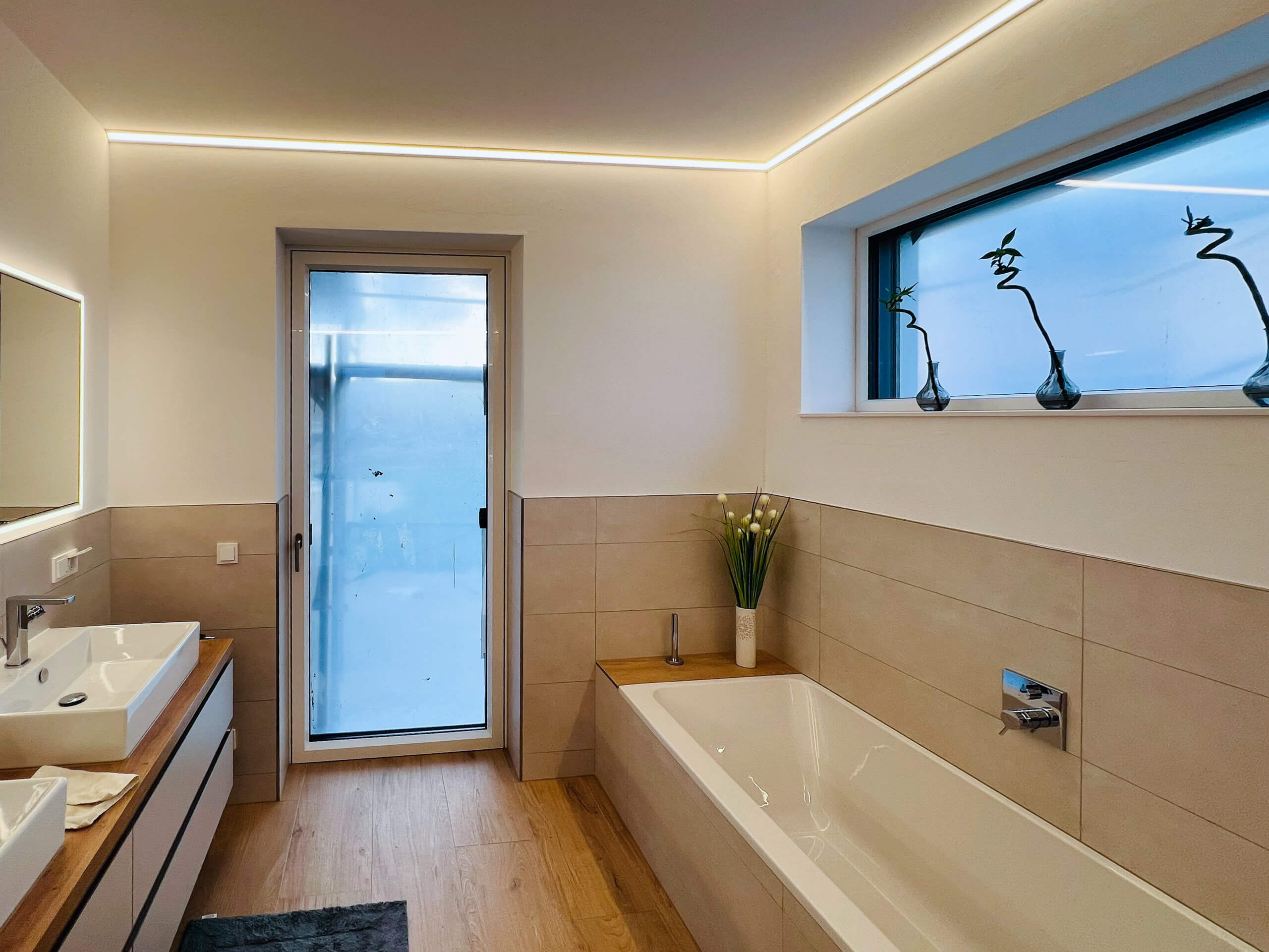 Modernes Badezimmer mit Badewanne und Dusche – Lichtplanung von Illumina