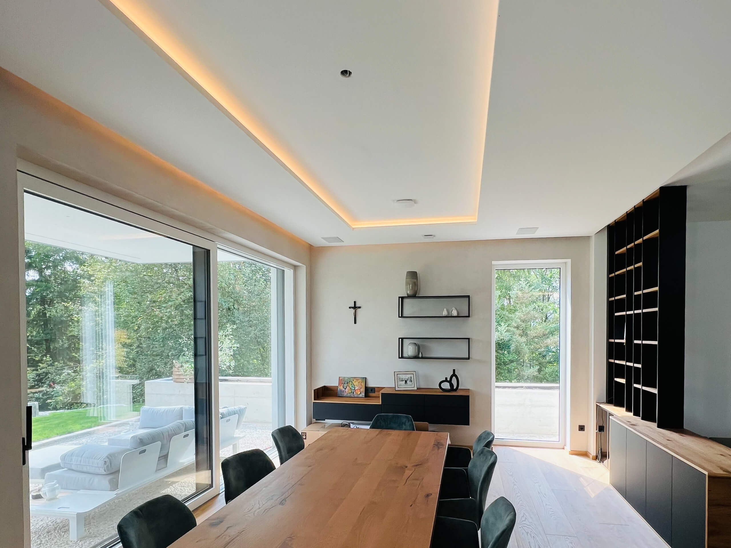Modernes Esszimmer mit großem Holztisch und indirekter Deckenbeleuchtung, Lichtplanung von Illumina.